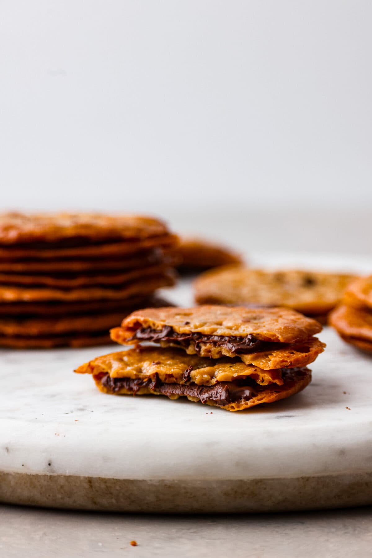 It doesn't get much better than crispy, caramelized cookies with a melted chocolate filling! These lace cookies are super easy to make and just what you need to satisfy your sweet tooth. A lace cookie broken in half.