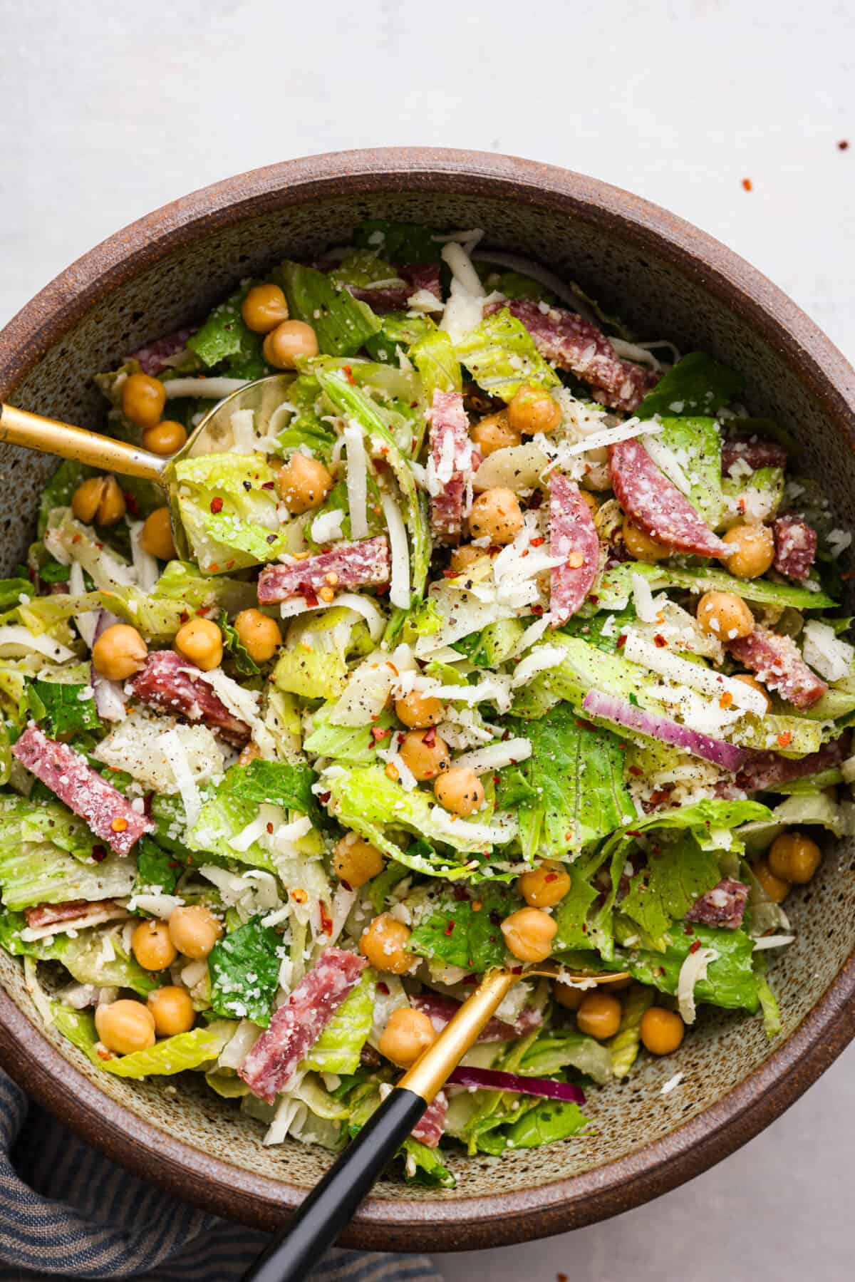 Fresh and flavorful, La Scala Salad is a copycat recipe of the famous Italian chopped salad served at La Scala restaurant in Beverly Hills. Rumor has it, Kim Kardashian orders this salad often, and for good reason! It's packed with delicious ingredients and crunchy texture, thanks to the chickpeas, salami, mozzarella cheese, and a zesty red wine vinaigrette. Top-down view of La Scala Salad in a large bowl.
