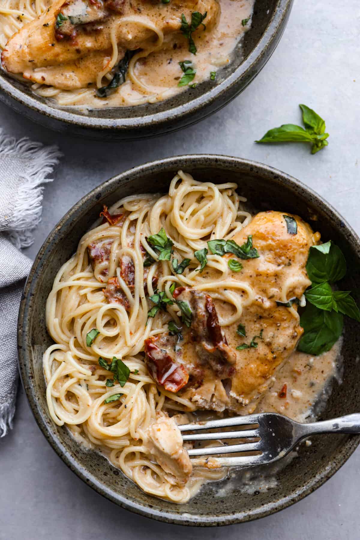 An amazing Tuscan dish made easy in the slow cooker! This Crock Pot Marry Me Chicken is slow cooked to tender perfection and smothered in a creamy, savory sauce made with sun-dried tomatoes and parmesan cheese. The perfect way to win anyone over! Crock Pot Marry Me Chicken served over spaghetti noodles.