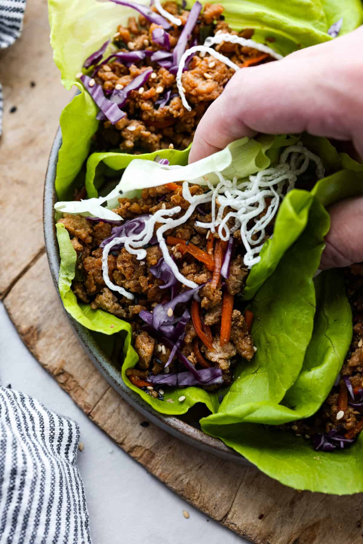 Healthy and easy, these Chicken Lettuce Wraps are so fresh and delicious! They're ready in under 30 minutes with a juicy chicken filling and crispy butterhead lettuce. Picking up a chicken lettuce wrap.