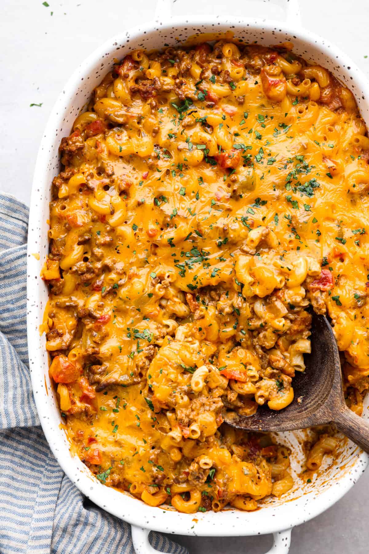 Cheeseburger Casserole has all of those delicious cheeseburger flavors in one easy-to-make dish! Loaded with ground beef, veggies, dill relish, pasta and plenty of cheese, all baked together for a comforting family-friendly dinner. Top-down view of a baked cheeseburger casserole.