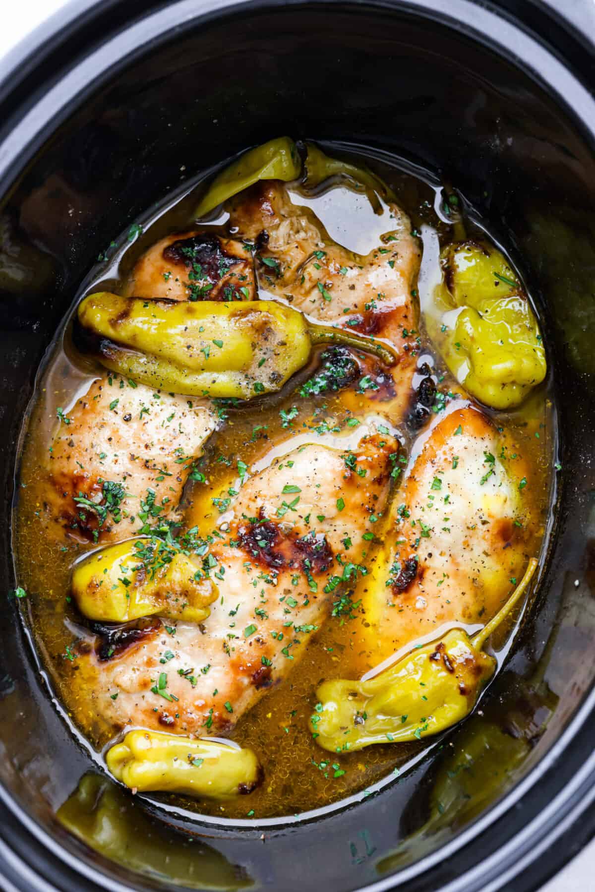 Crockpot Mississippi Chicken is all about fork-tender, juicy chicken that's bursting with flavor. You've got zesty pepperoncini peppers, ranch seasoning, au jus mix, and butter that slow cooks with it for some seriously amazing flavor. It's the perfect Southern comfort meal! Cooked Mississippi chicken in a crockpot.