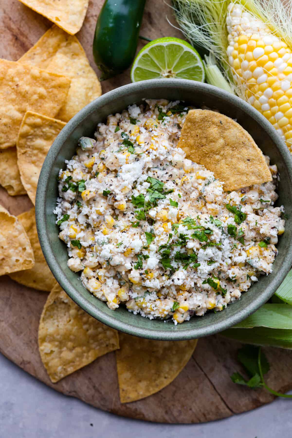 Dive into the irresistible taste of Mexican street corn with this easy-to-make dip. Charred corn, green chilies, spices, and creamy mayo blend perfectly for a delicious appetizer for any occasion! The top view of a bowl of Mexican Street Corn Dip