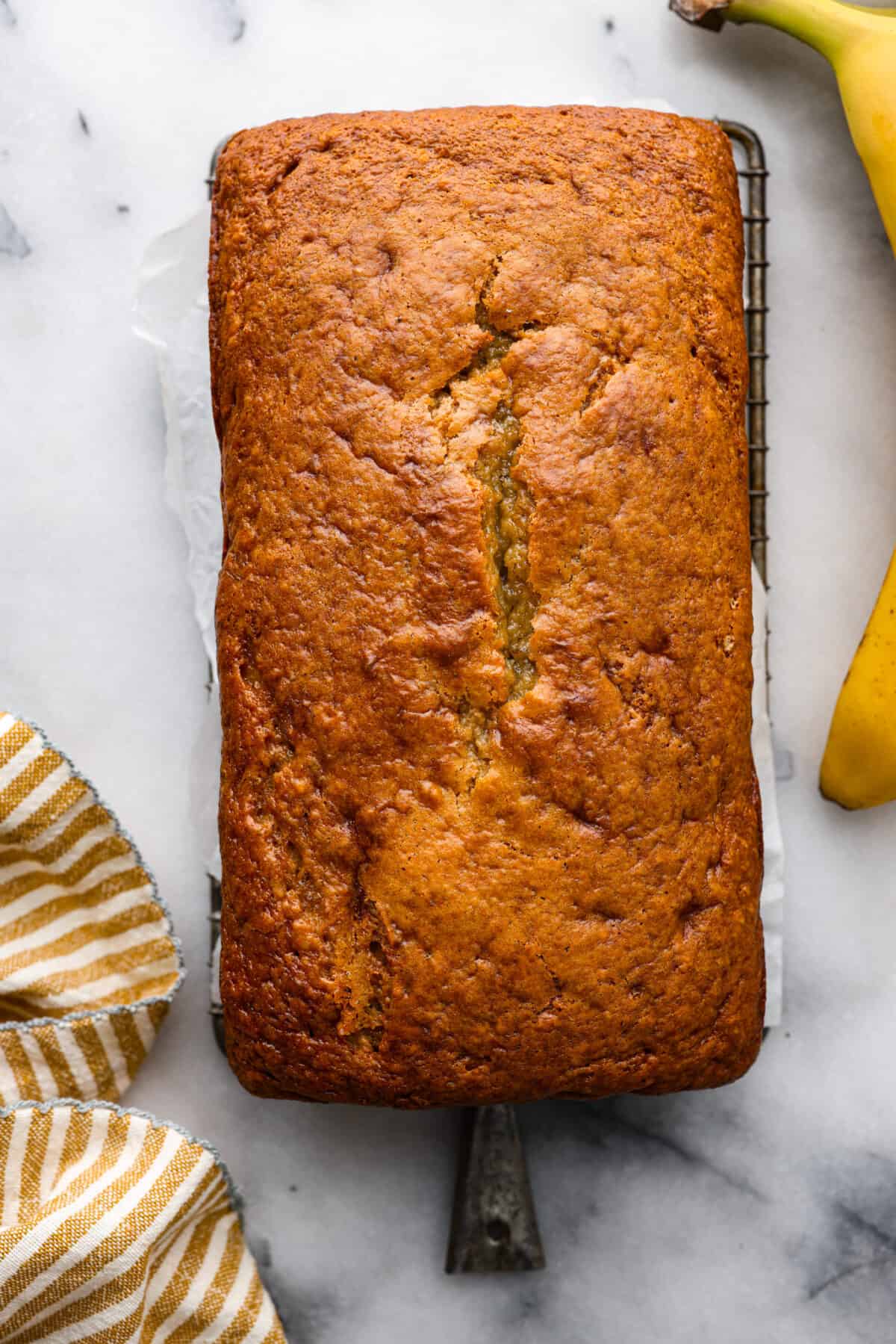 Make your homemade banana bread even more tender and delicious by adding in sour cream! This recipe is the best youโll try, and you wonโt be able to stop at one piece! Top-down view of a whole loaf of sour cream banana bread.