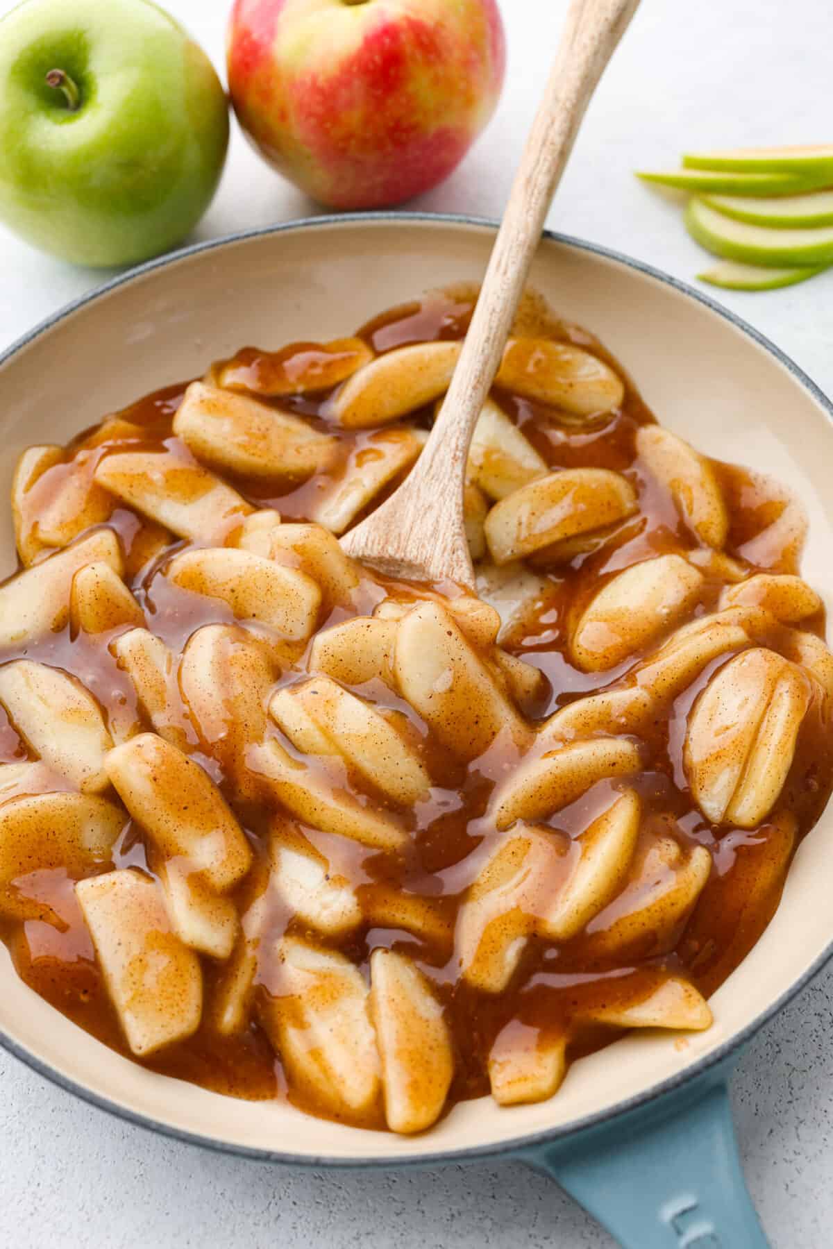 Make your Thanksgiving pies taste even better this year with some fresh apple pie filling! It has the perfect, glossy consistency and tastes absolutely delicious with the added cinnamon and nutmeg. The perfect substitute for canned apple pie filling. Plus, it's easy to freeze for later. Apple pie filling being stirred in a blue and white skillet.