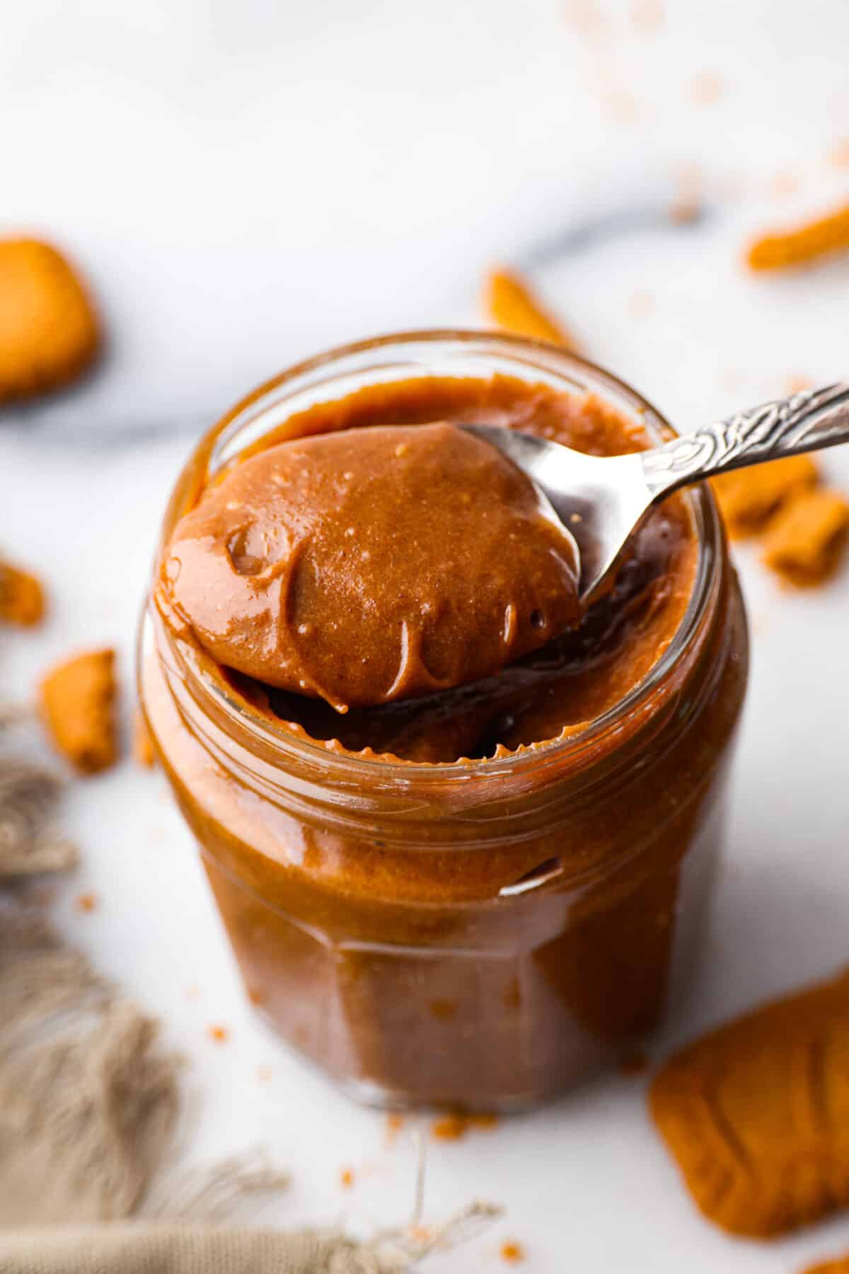 If you love Trader Joe's and you love their cookie butter, you are going to LOVE this recipe. This homemade version tastes exactly like it (except better), and then you can have it on hand all year long! Cookie butter being scooped out with a spoon.