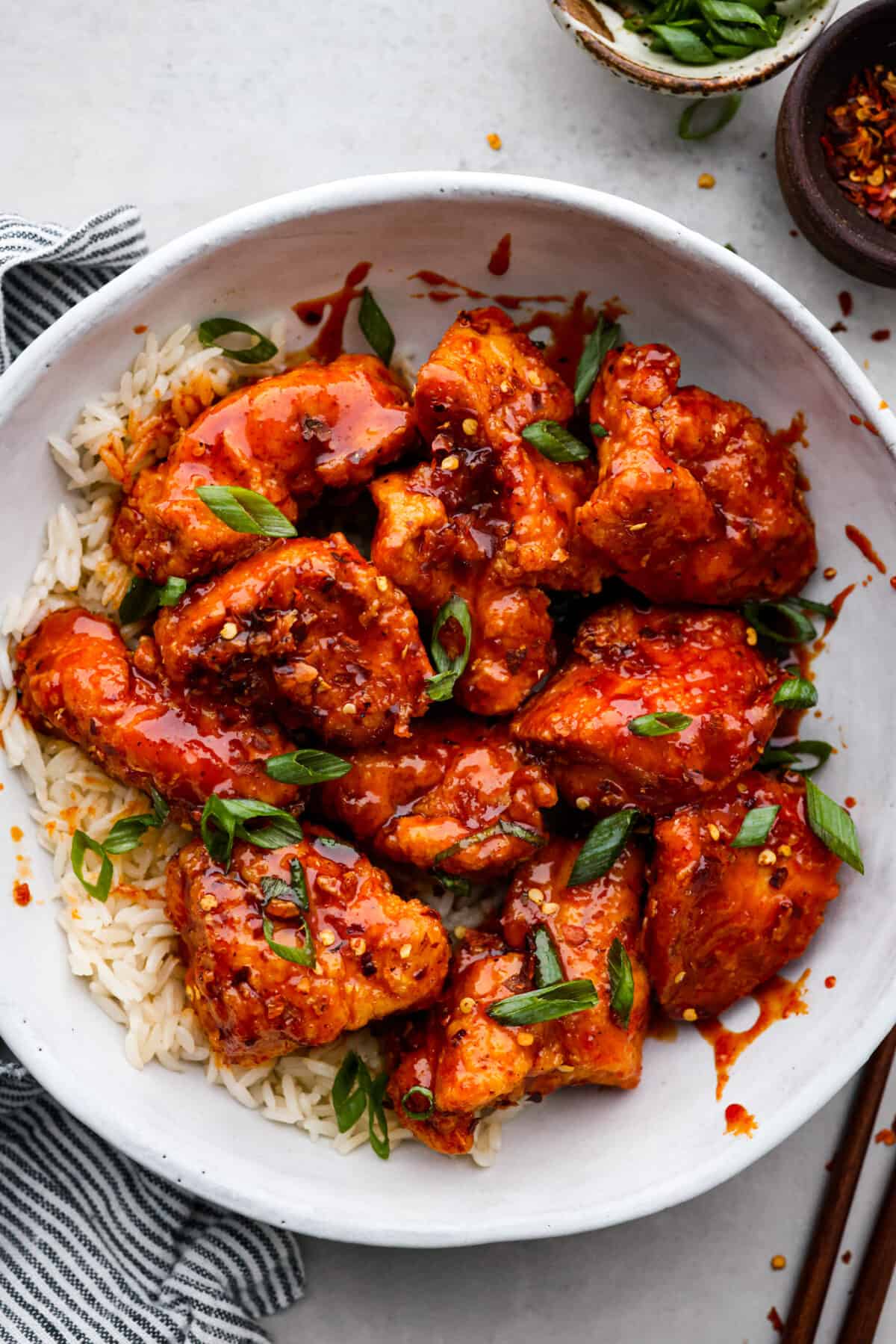 Korean fried chicken or yangnyeom chicken has juicy breaded chicken tossed in a sweet and spicy glaze, itโs what dreams are made of! Gochujang paste gives it its classic spicy flavor, but the added honey and brown sugar tones it down enough that the whole family will love it. One bite and you'll be addicted! Korean fried chicken served over rice in a white bowl.