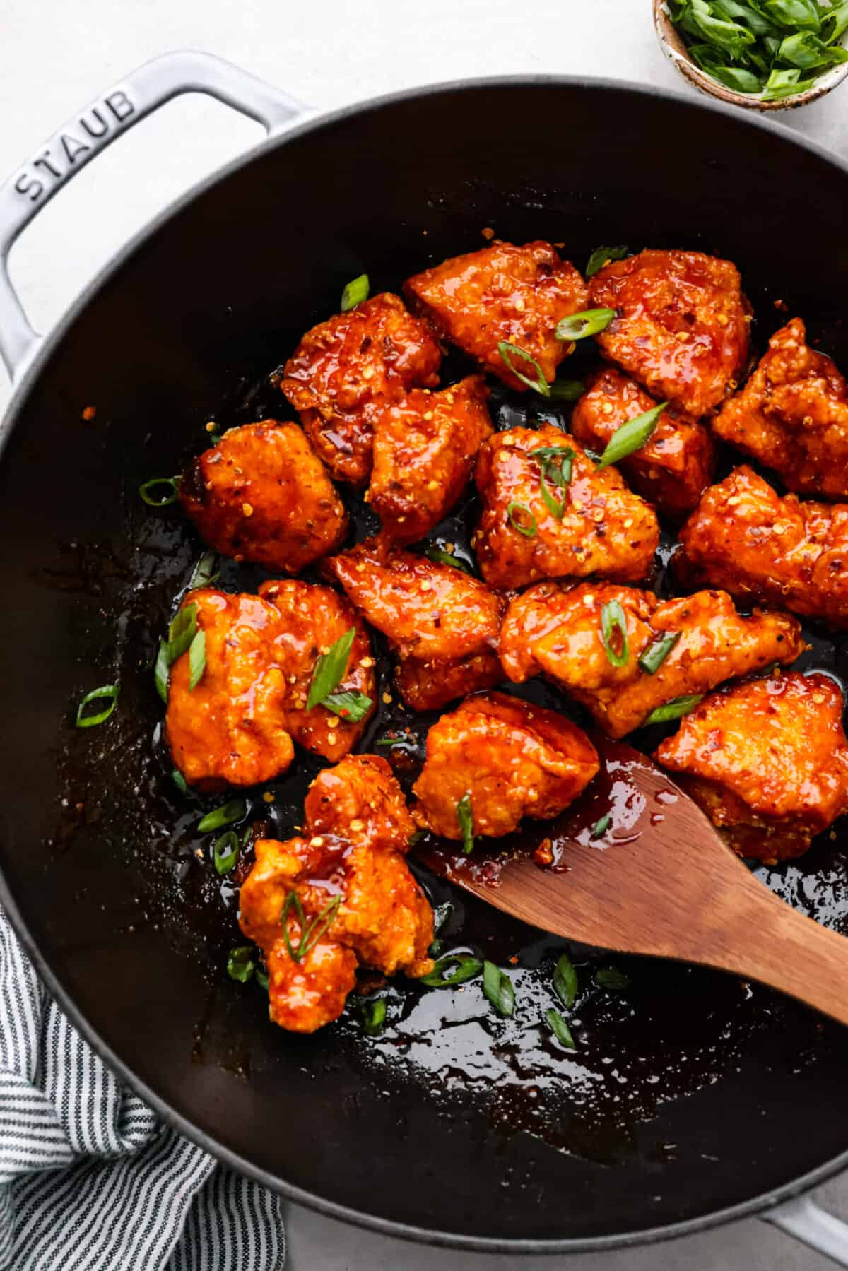 Korean fried chicken or yangnyeom chicken has juicy breaded chicken tossed in a sweet and spicy glaze, itโs what dreams are made of! Gochujang paste gives it its classic spicy flavor, but the added honey and brown sugar tones it down enough that the whole family will love it. One bite and you'll be addicted! Fried chicken pieces in a skillet.