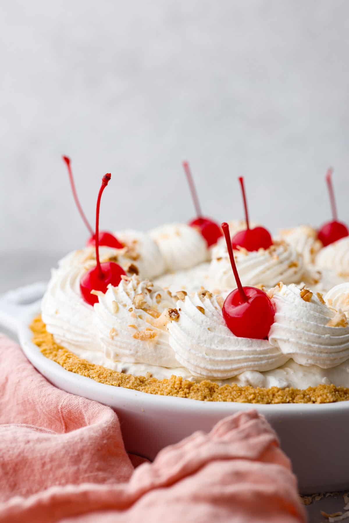 Named 'Million Dollar Pie' because it's so rich and delicious, this scrumptious dessert is the perfect way to satisfy your sweet tooth! It's light and fluffy but packed with coconut, pecans, and pineapple for tasty tidbits in each bite! A whole million dollar pie, topped with whipped cream and maraschino cherries.