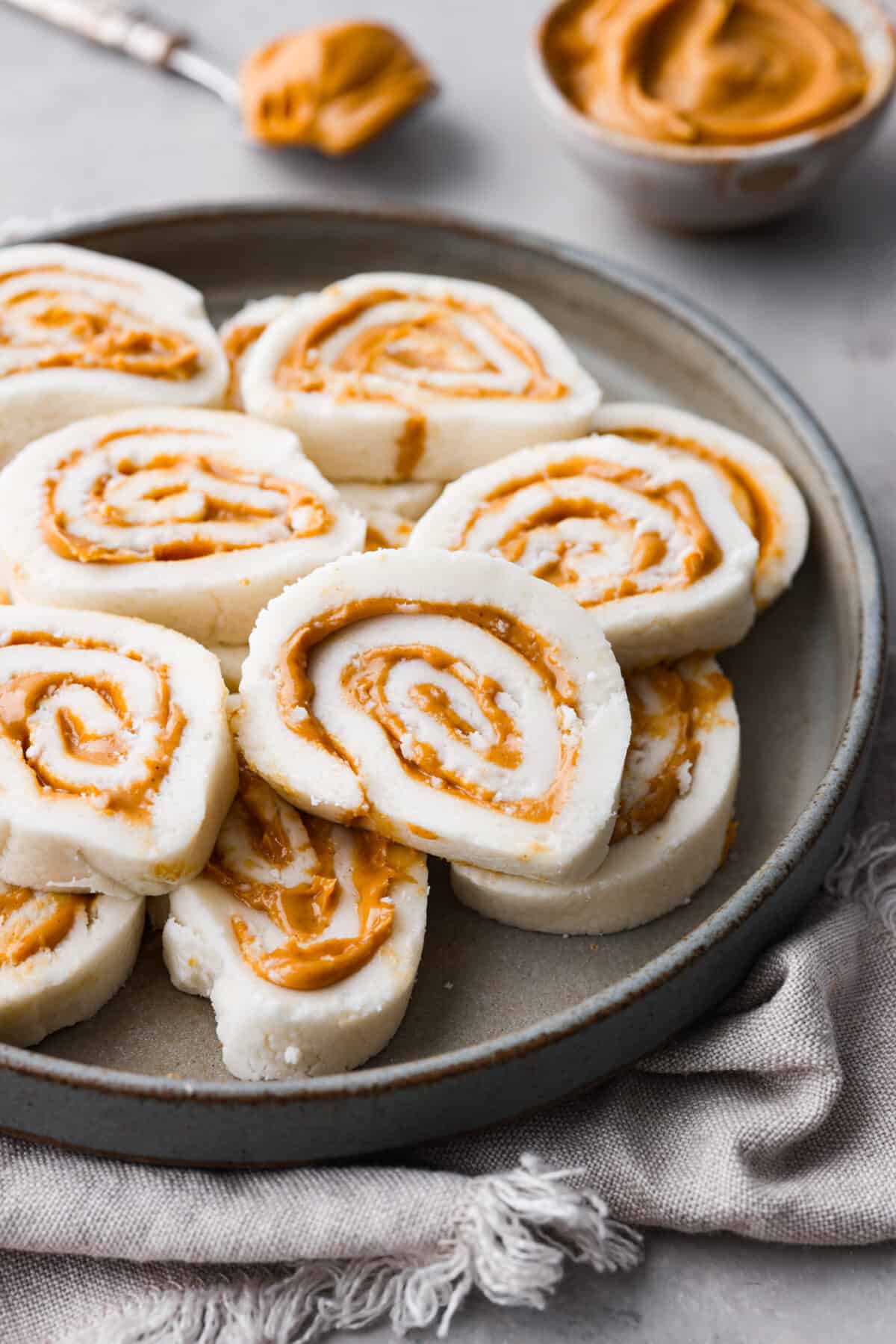 This Peanut Butter Pinwheel Candy recipe has been passed down in my family for generations! These are soft, fluffy, and full of amazing peanut butter flavor. You won't believe what the secret ingredient is that makes these so incredible! Close up shot of peanut butter pinwheel candy.
