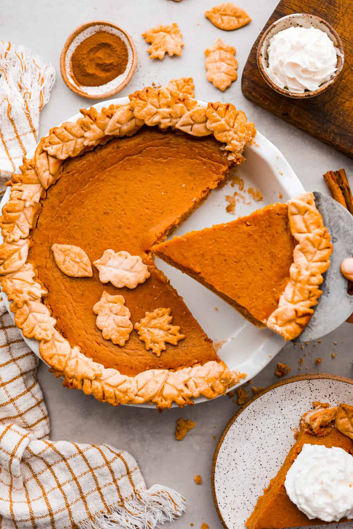 Grandma's famous pumpkin pie is smooth, thick, and creamy! A MUST for the holidays and the best when served with a big dollop of whipped cream on top! Top-down view of pie with slices cut out of it.