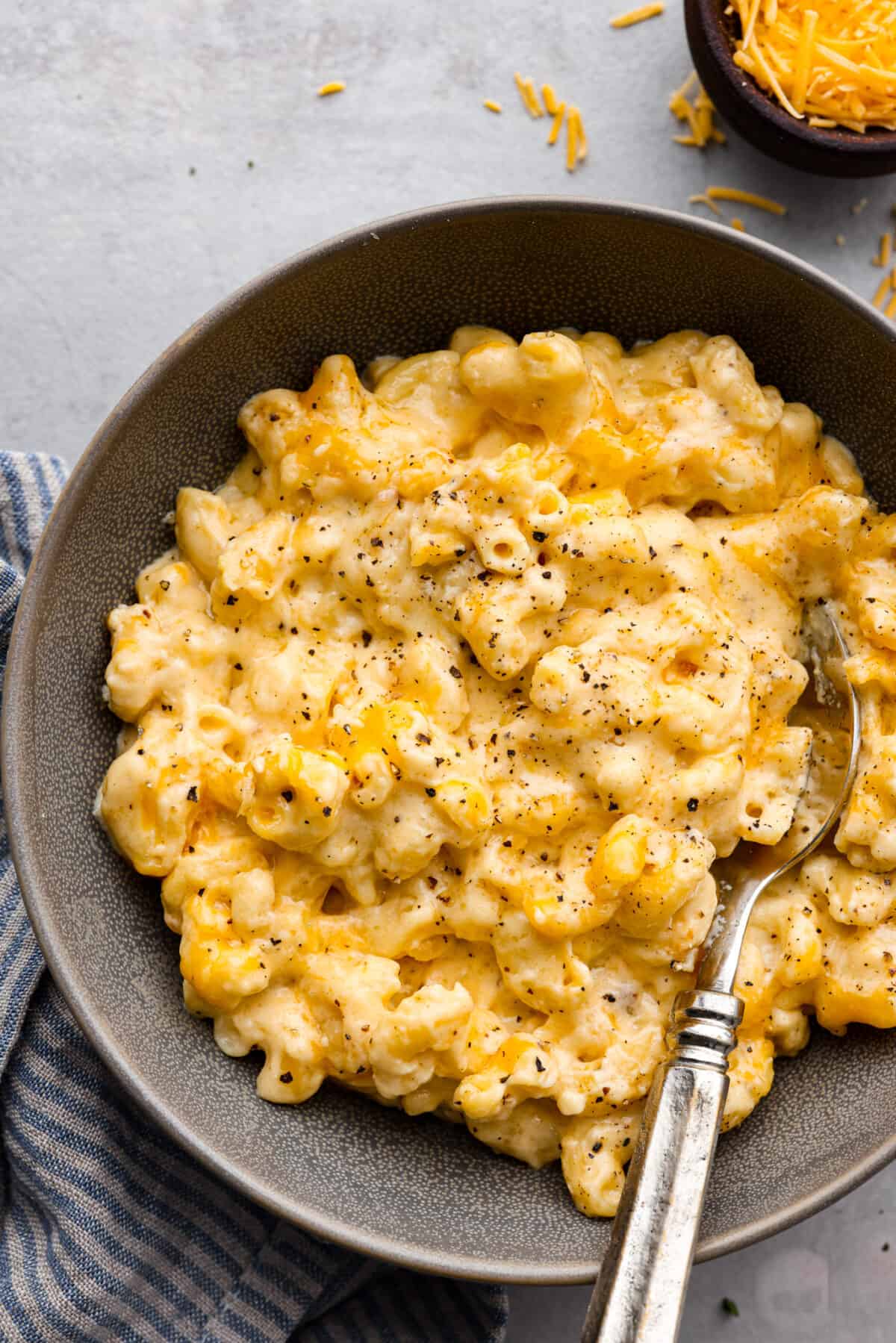 This Slow Cooker Macaroni and Cheese is creamy, comforting and perfect for potlucks. Best of all, it comes together easily in the crock-pot โ even the pasta! A serving of macaroni and cheese in a gray dish.