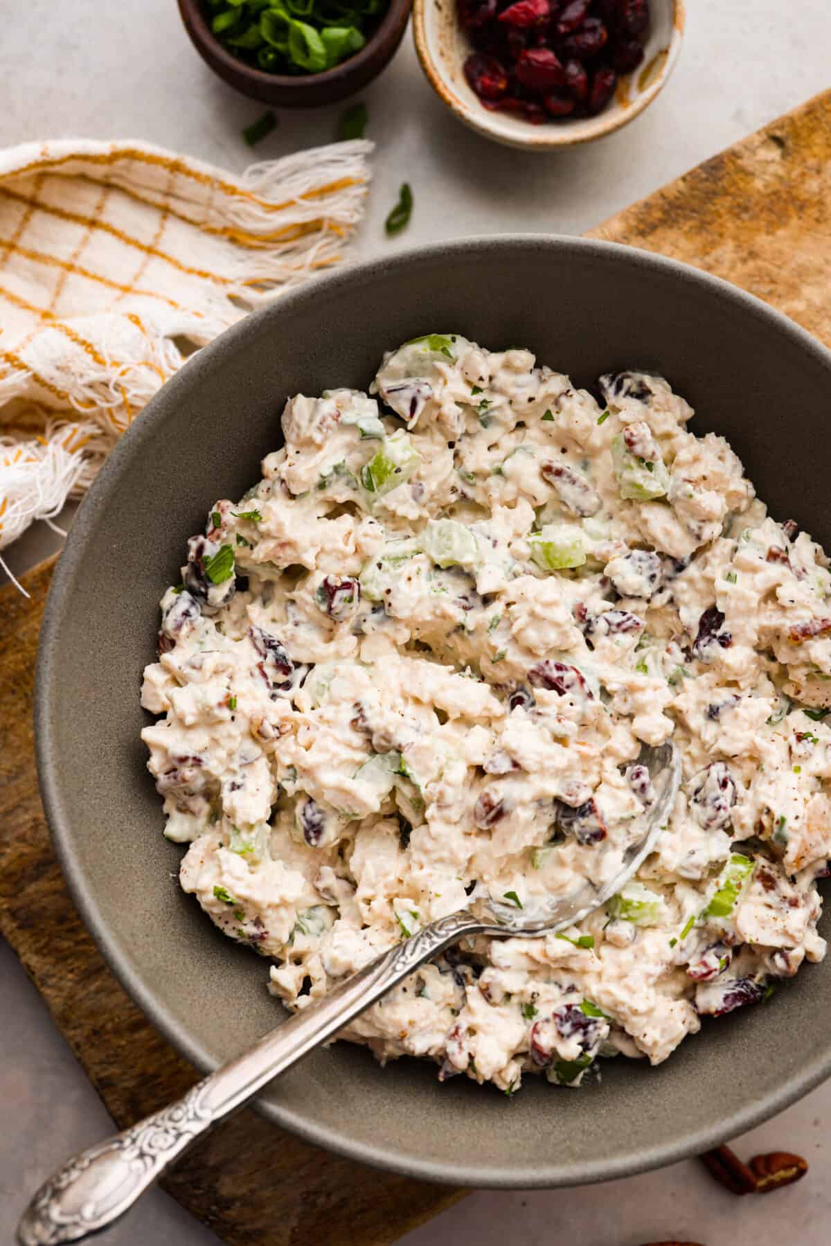 This Turkey Salad is a fresh, satisfying dish loaded with fruit, veggies, and nuts. It comes together quickly and is the perfect way to use up leftover turkey from Thanksgiving! Turkey salad served in a gray bowl.