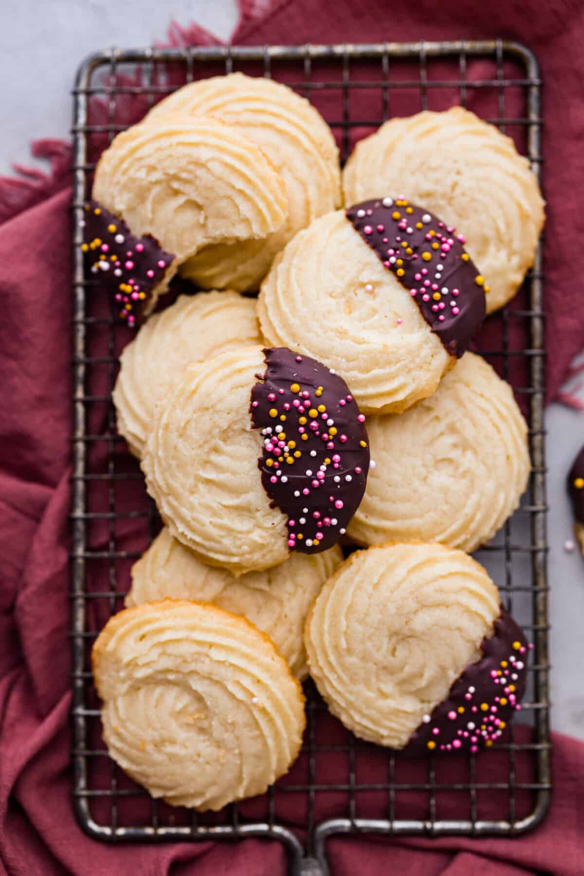 Buttery, tender, and unbelievably light, these homemade Danish butter cookies are so much better than the tinned version. Loaded with flavor, these cookies will melt in your mouth and are so easy to make. Top view of cookies stack on a cooling rack.