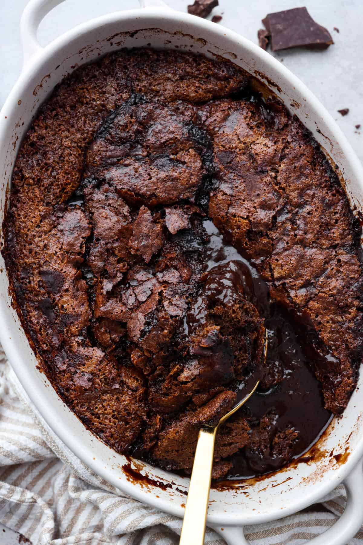 Everyone will want to eat dessert first with this Chocolate Cobbler โ a simple dessert that's all about gooey chocolate goodness. The velvety inside and crispy top create a perfect combo for a satisfying, easy-to-make treat! The top view of chocolate cobbler in an oval baking dish.