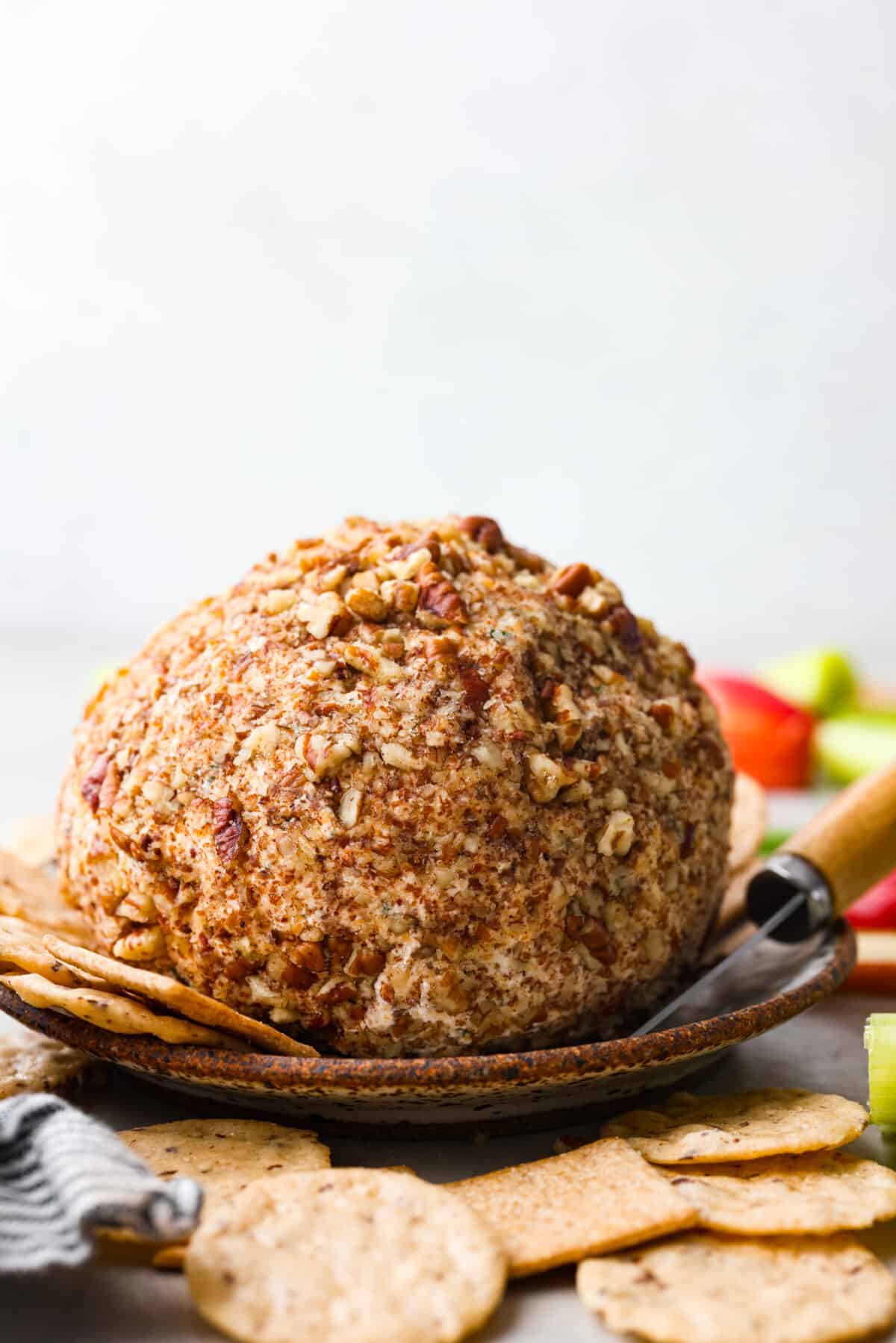This is my go-to classic cheese ball! It's deliciously cheesy with a mix of cream cheese, cheddar cheese, green onion and seasonings that gets shaped into a ball, then rolled in crunchy pecans. It’s packed with flavor and makes the best holiday appetizer! A cheese ball, coated in pecans.