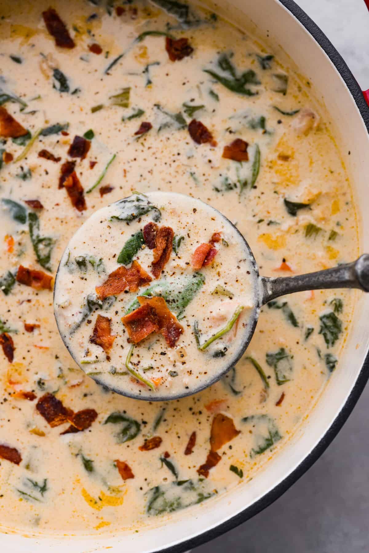 All it takes is one bite to obsess over this crack chicken soup! It's loaded with shredded chicken, bacon, ranch seasonings, and all of your favorite creamy crack-inspired flavors! Top view of crack chicken soup in a pot with a ladle lifting up soup.