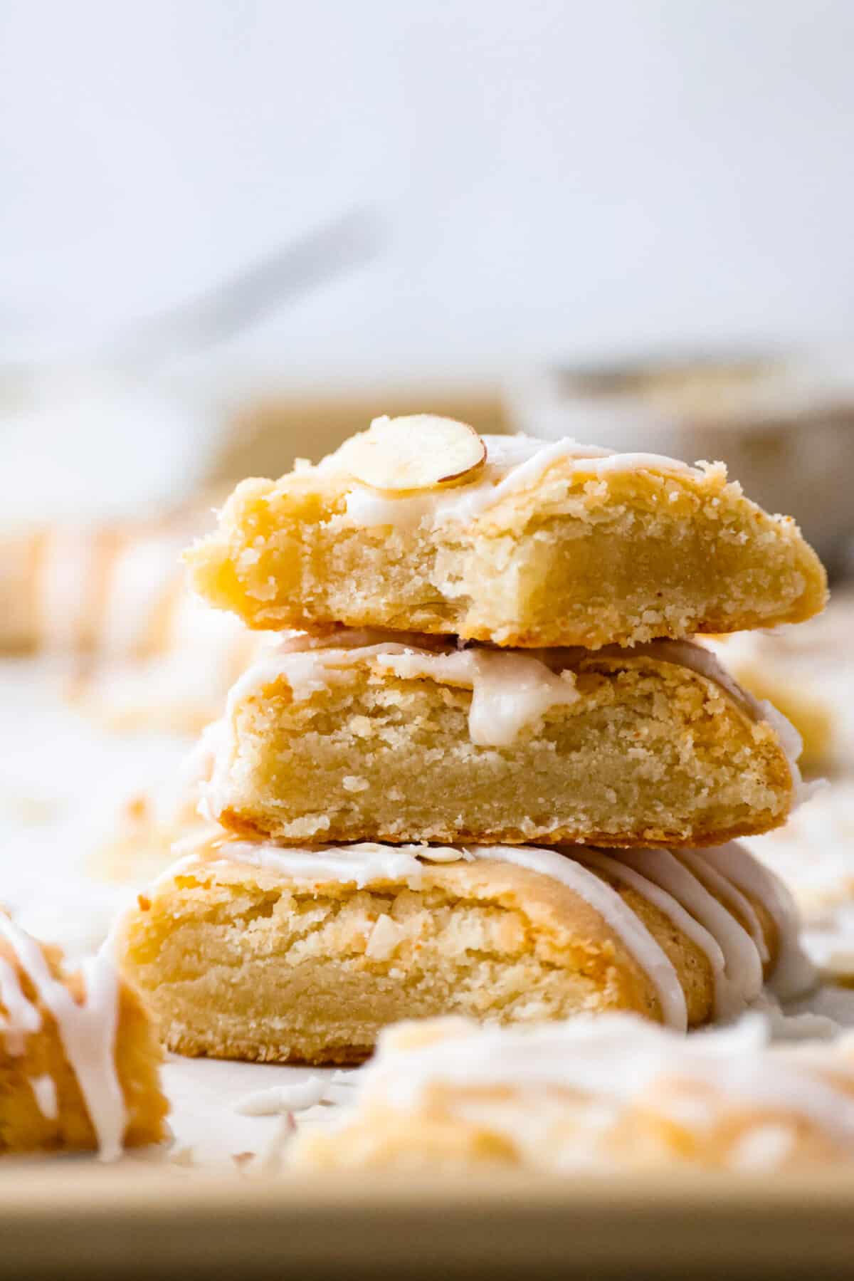This Danish Kringle is full of almond flavor, baked until golden, and then drizzled with a vanilla glaze. This can be eaten for breakfast or dessert, and everyone will love it! A stack of sliced Danish Kringle.