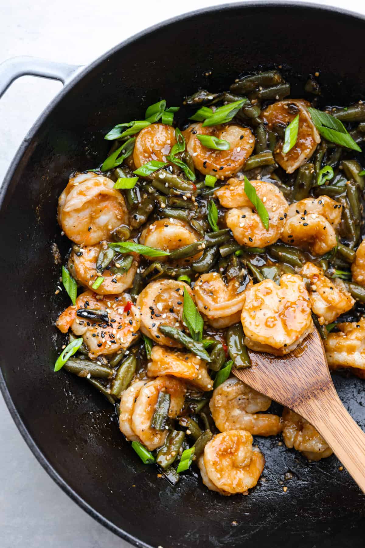 Crispy coated shrimp gets pan-fried to golden perfection in this better-than-takeout recipe! Tossed with tender veggies in a savory-sweet sauce, Hunan Shrimp is sure to be a new favorite in your dinner rotation. Cooked Hunan shrimp and green beans in a black skillet.
