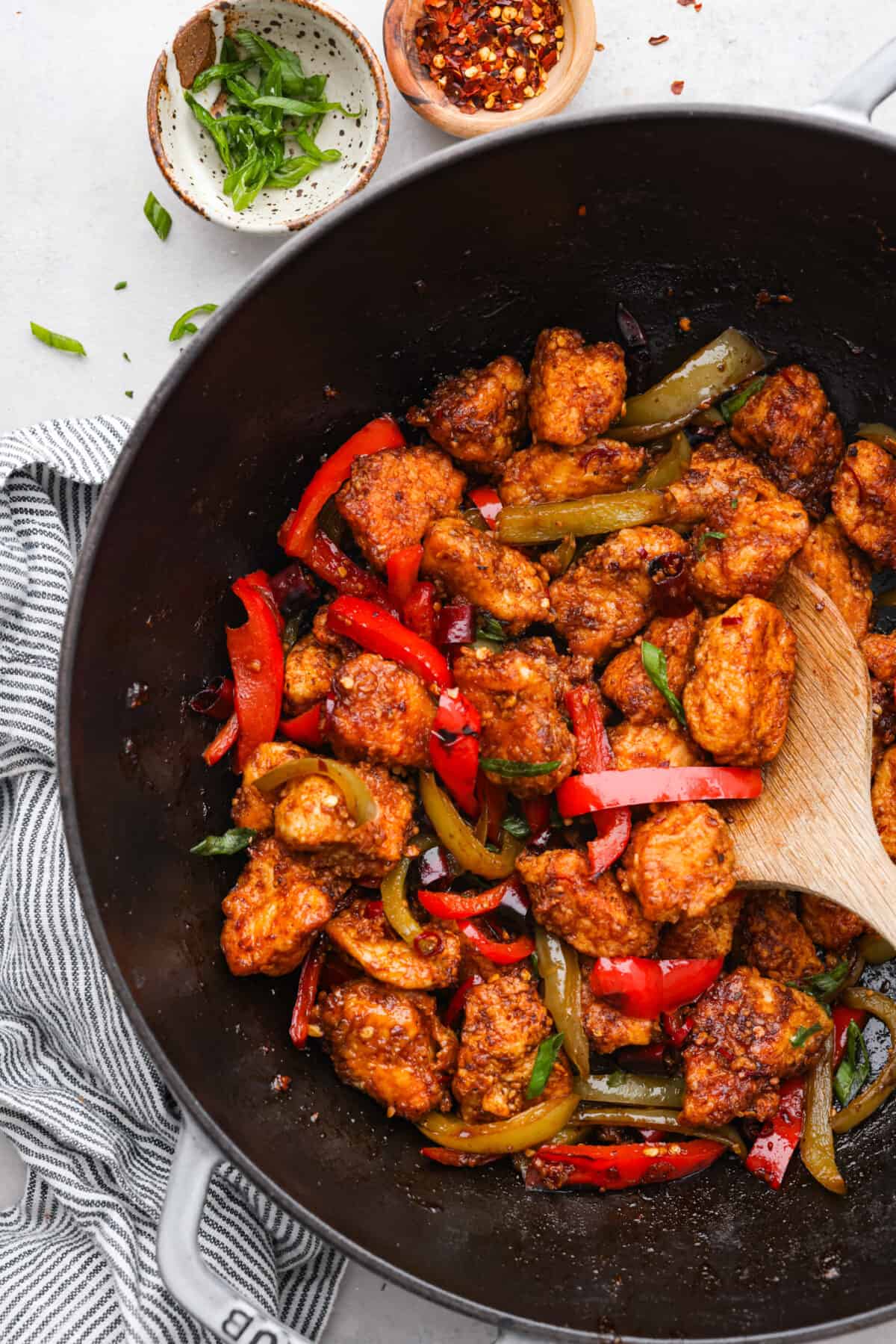 A takeout favorite for good reason! Kung pao chicken is pan-fried to crispy perfection and coated in a spicy, savory sauce that will leave you wanting more. Once you try making it from scratch, you won’t want it any other way! Cooked kung pao chicken with bell peppers in a black wok.