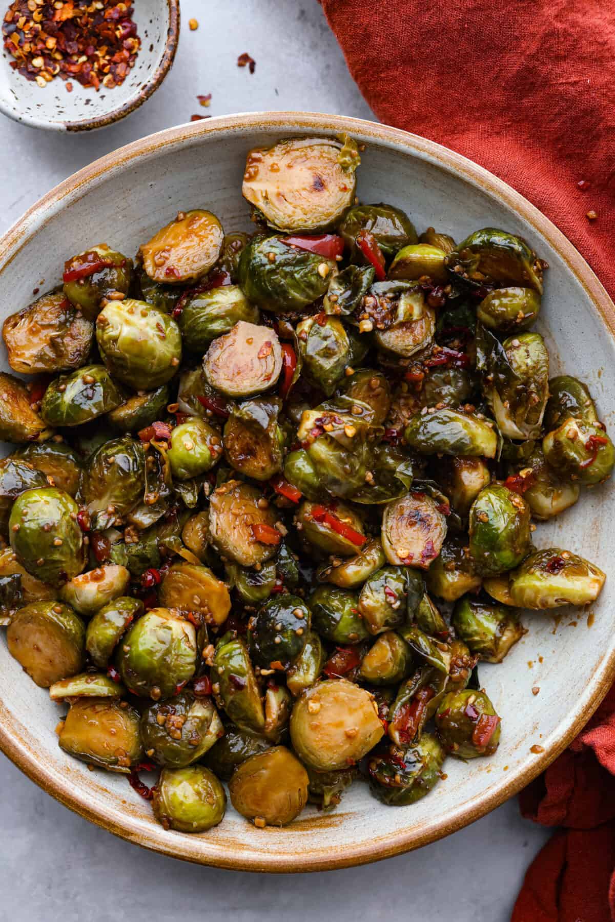 A classic Chinese takeout dish but made with one of my favorite veggies! Kung Pao brussels sprouts are stir-fried until they’re crisp and tender and have a kick of savory-spicy flavor in each bite. Simple, delicious, and guaranteed to please! Kung Pao Brussels sprouts in a stoneware bowl.