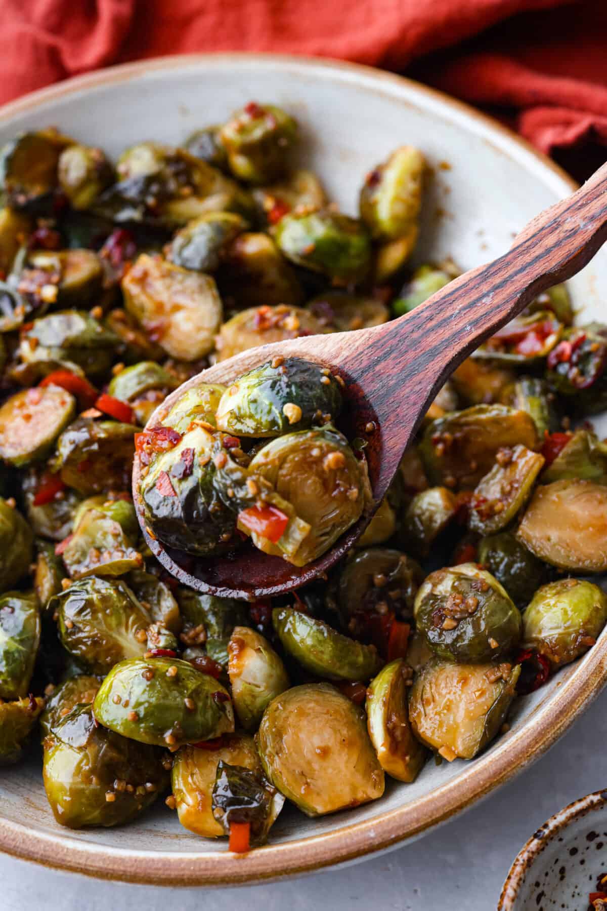 A classic Chinese takeout dish but made with one of my favorite veggies! Kung Pao brussels sprouts are stir-fried until they’re crisp and tender and have a kick of savory-spicy flavor in each bite. Simple, delicious, and guaranteed to please! Sprouts being scooped up in a wooden spoon.