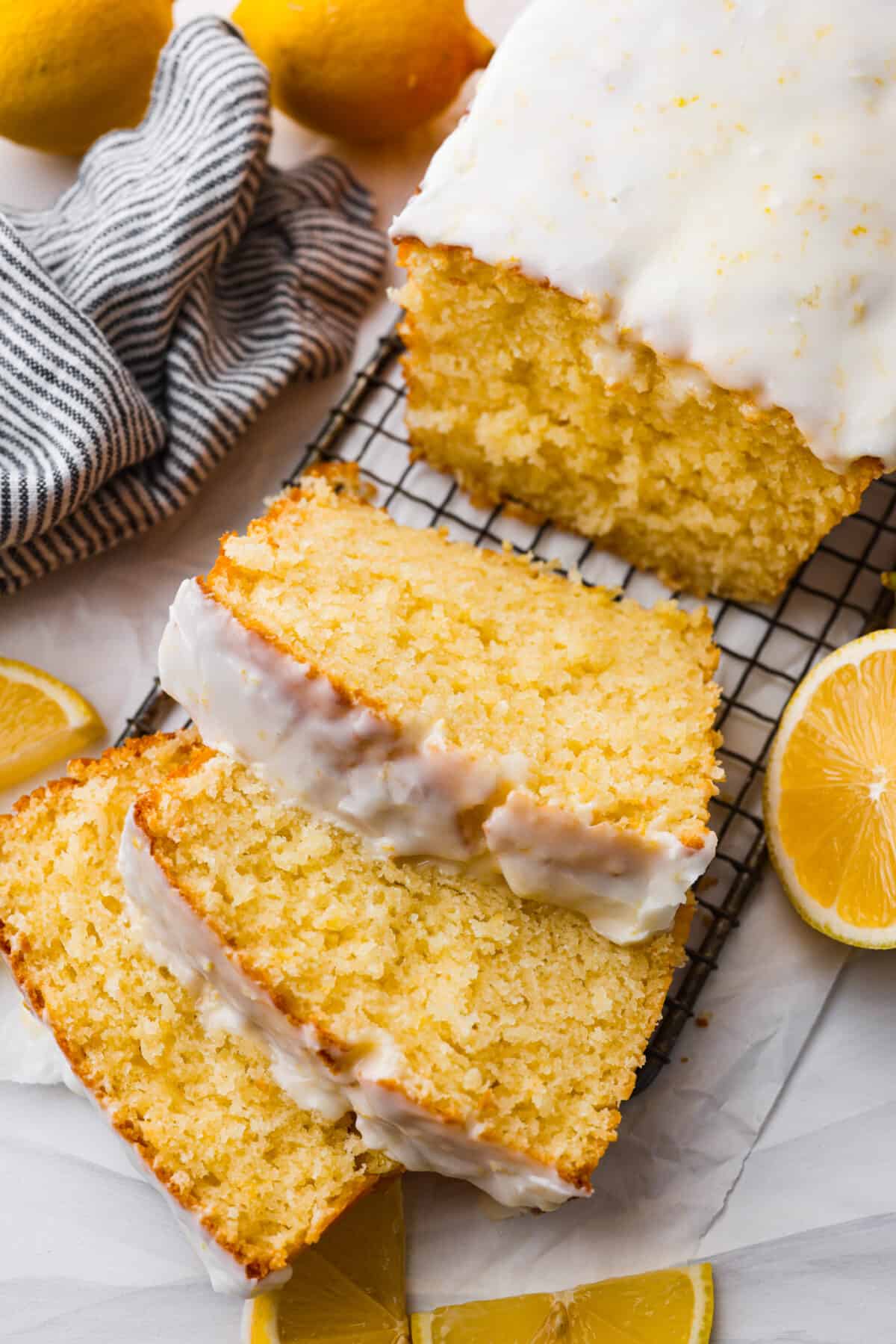 Bring the irresistible taste of Starbucks Lemon Loaf to your home with this easy-to-make recipe. A perfect blend of zesty lemon and moist texture, topped with a simple lemon icing โ enjoy the homemade version of this beloved Starbucks treat! The top view of a lemon loaf on a cooling rack topped with a lemon glaze and sliced.