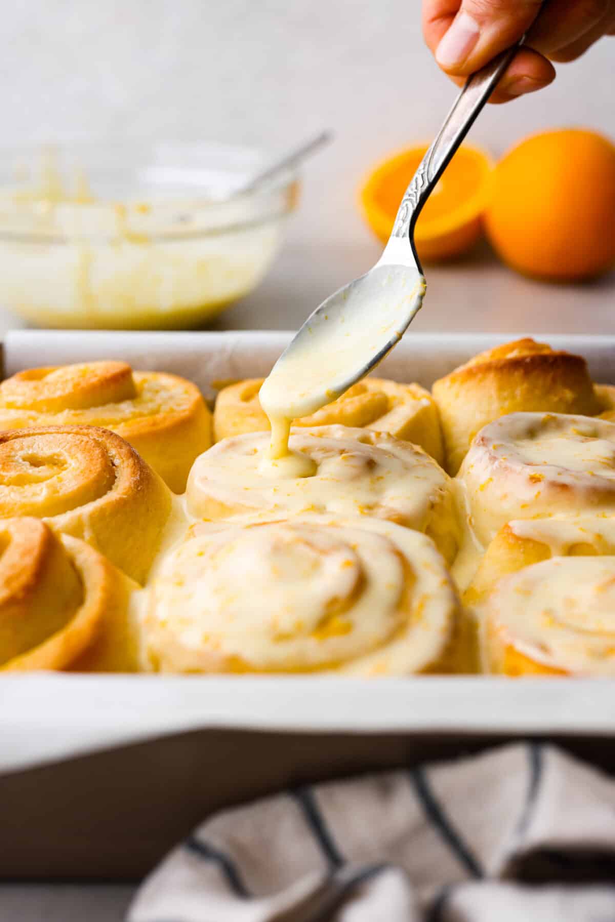 Sticky and soft with a vibrant orange flavor, these orange rolls are the best youโll find. Simple to make, these are the zesty sister to a cinnamon roll! Glaze being drizzled on orange rolls.