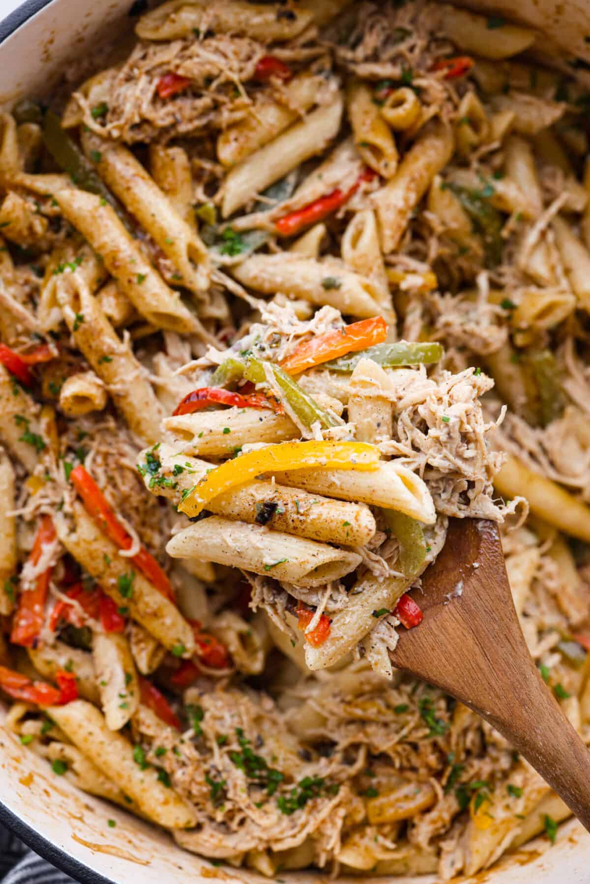 This incredibly flavorful Rasta Pasta recipe features penne pasta cooked al dente and tossed with sautรฉed peppers and shredded chicken in a rich, creamy, spiced sauce. A spoonful of rasta pasta.