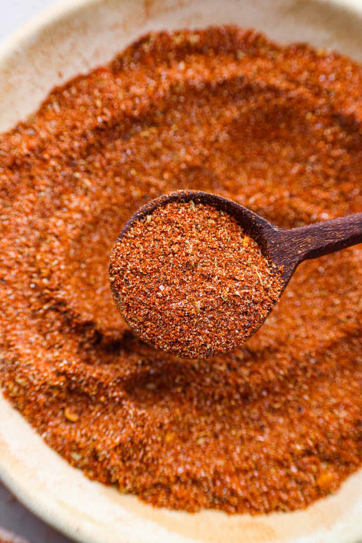 Enjoy the flavors of the Southwestern states in this tasty southwest seasoning! This homemade seasoning uses classic spices used in Southwestern cuisine. It's delicious on chicken, in tacos, or added flavoring in many dishes. Close view of a wood spoon lifting up a scoop of seasoning.