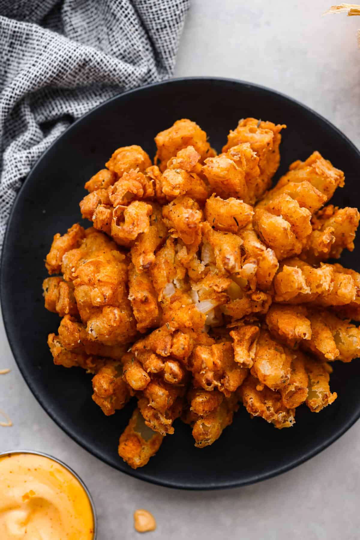 The best of the best when it comes to appetizers, this crispy bloomin' onion is the best addition to any meal. Each onion is coated in a seasoned buttermilk breading that will have you reaching for another piece. Top-down view of a bloomin onion.