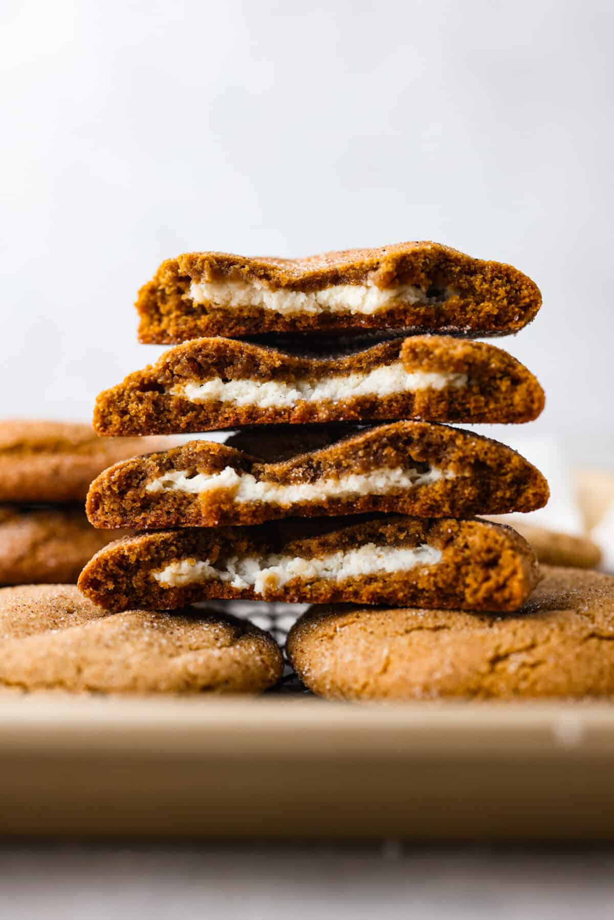 A fun twist on a holiday favorite! These cheesecake stuffed gingerbread cookies are soft and spiced to perfection, filled with a rich and creamy filling. Each bite is a dream! 4 cookie halves stacked on top of each other.