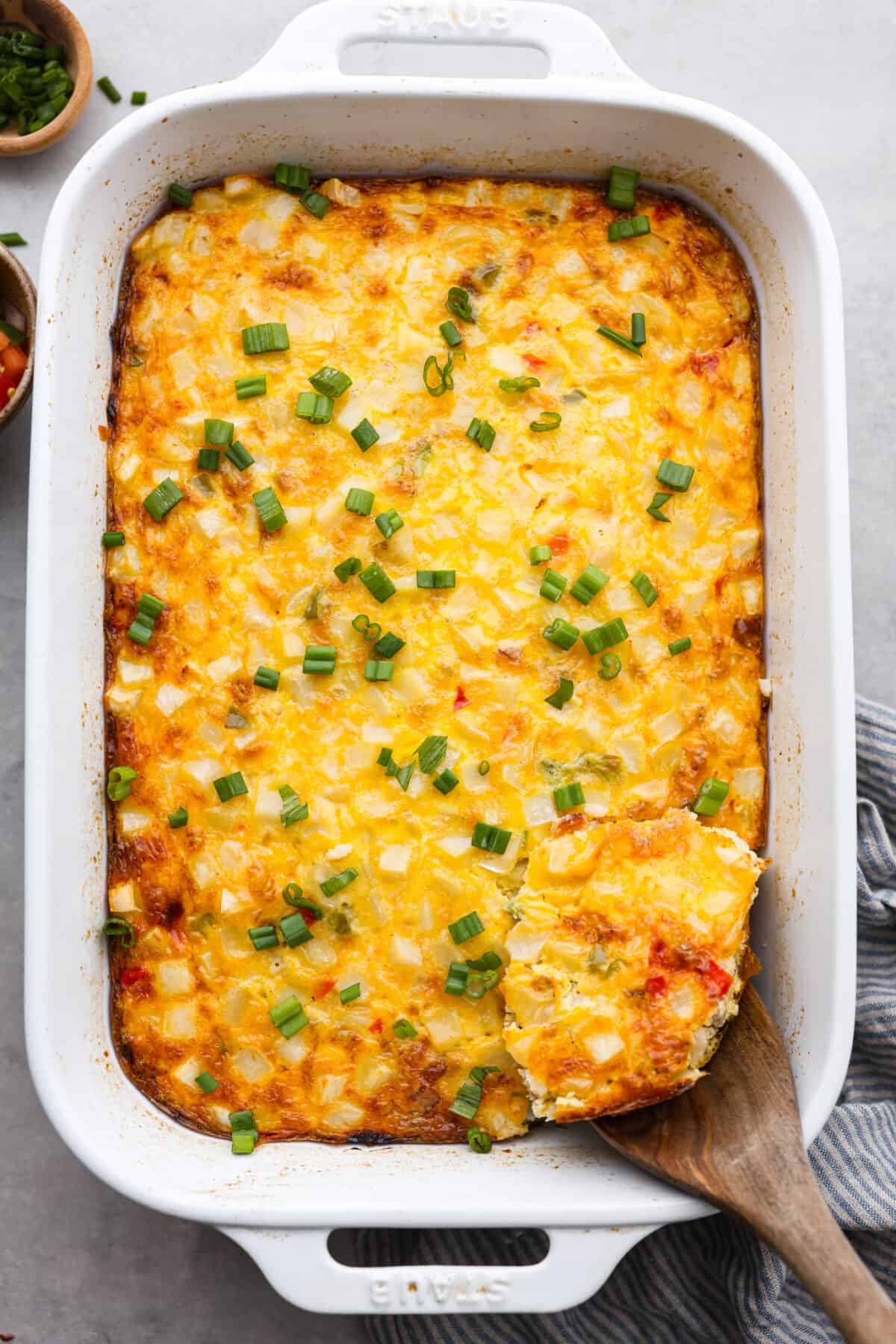 Cowboy breakfast casserole is a hearty dish that's chock full of breakfast favorites (eggs, bacon, sausage, beans, cheese, potatoes, and more!) and super easy to make! Top-down view of a baked breakfast casserole.
