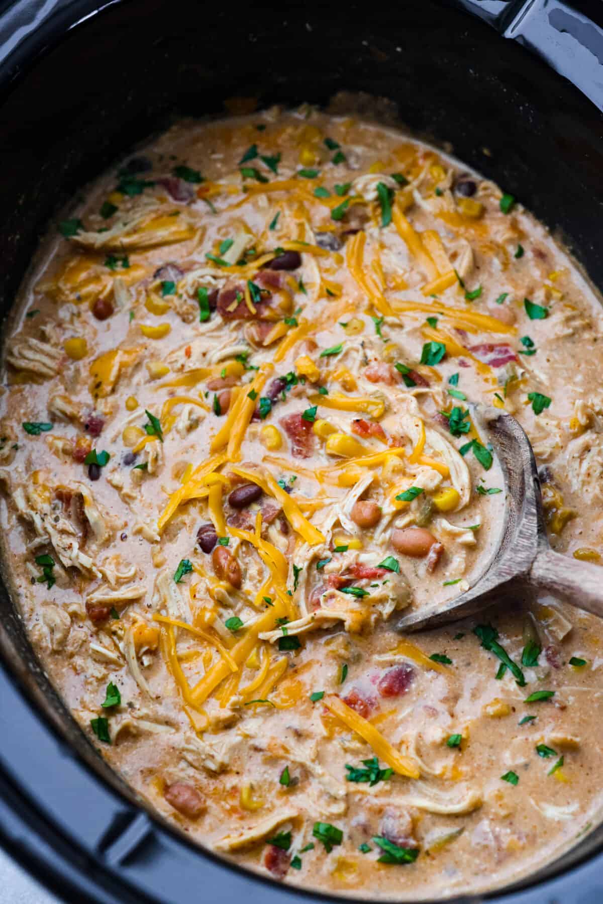 Creamy crack chicken chili is an explosion of irresistible flavors! It's loaded with shredded chicken, tender beans, corn, AND all your favorite crack-inspired ingredients. This is our new favorite chili recipe and we can't get enough of it!