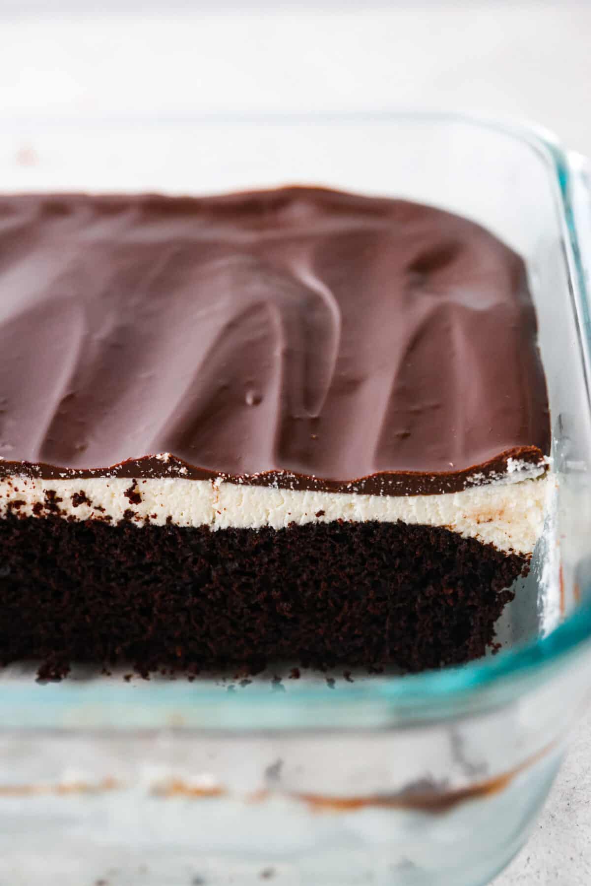 Transform your favorite childhood snack cake into a decadent ho ho cake. Inspired by a Hostess ho hos, this dark chocolate cake is topped with cream filling and fudgy ganache frosting. Every bite takes you back to feeling like a kid again! Close view of the cake layers showing in the pan.