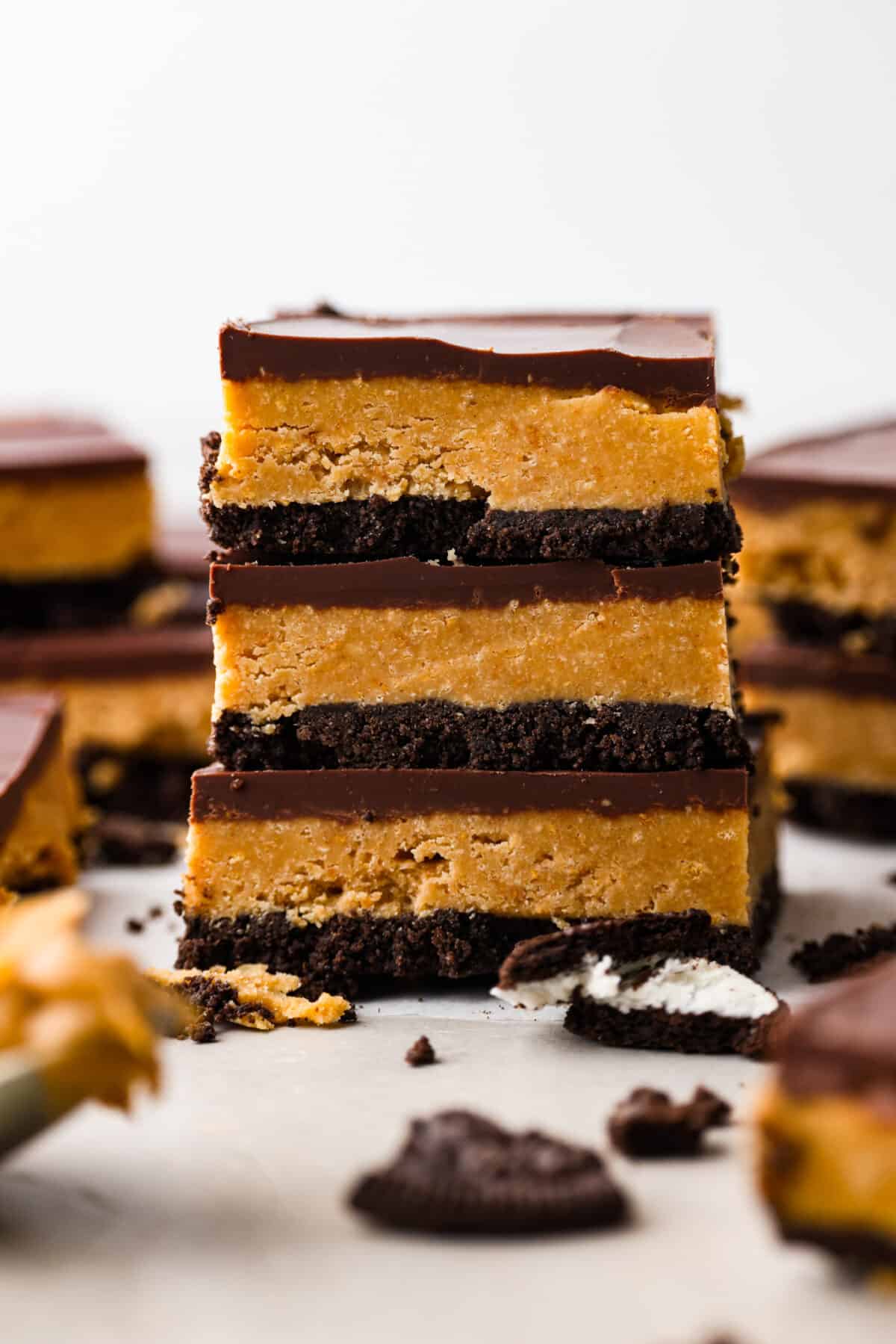 Creamy peanut butter and melted chocolate layered on top of an Oreo crust. What could be better than that? These Oreo peanut butter bars are what dessert dreams are made of! 3 Oreo peanut butter bars stacked on top of each other.