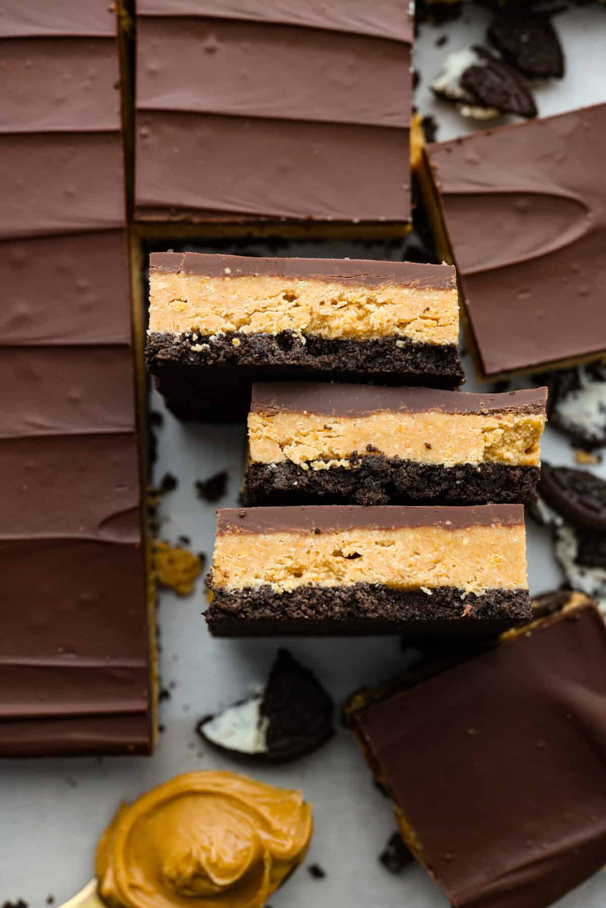 Creamy peanut butter and melted chocolate layered on top of an Oreo crust. What could be better than that? These Oreo peanut butter bars are what dessert dreams are made of! Chocolate peanut butter bars, cut into squares.