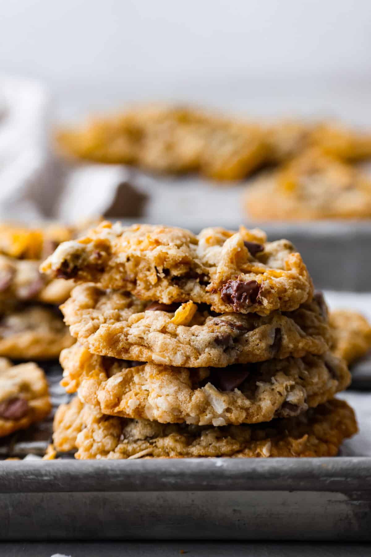 Delicious Ranger Cookies (also called Cowboy Cookies) have slightly crisp edges with soft and chewy centers, and the most wonderful texture. They are filled with hearty oats, crunchy cornflakes, shredded coconut and chocolate chips. You will be blown away by how amazing these cookies taste! 4 ranger cookies stacked on top of each other.