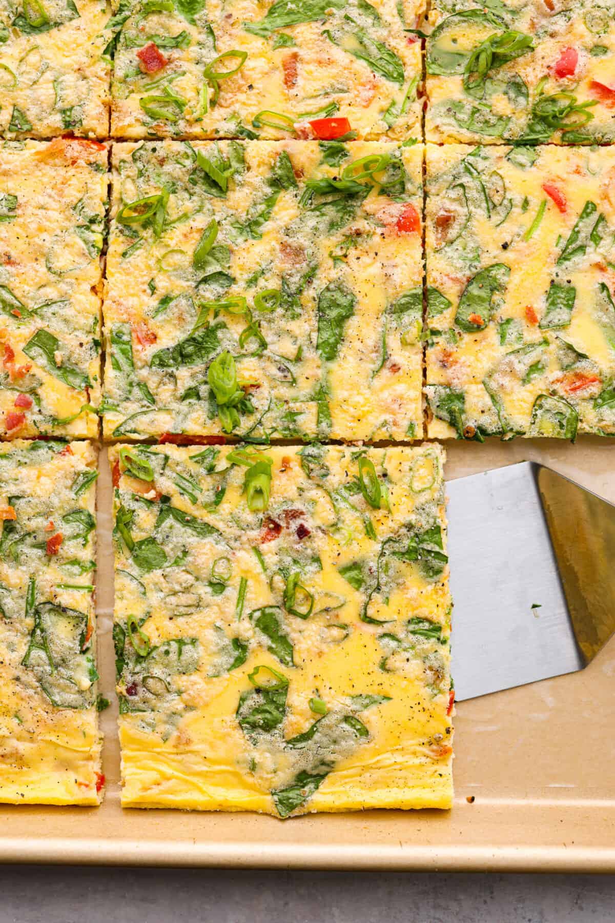 Sheet pan eggs are not only fluffy and full of flavor, but the best way to meal prep eggs or feed a crowd! Add your favorite mix-ins and serve as-is or use them to make breakfast sandwiches or as a topping for avocado toast! Sheet pan eggs, cut into squares.