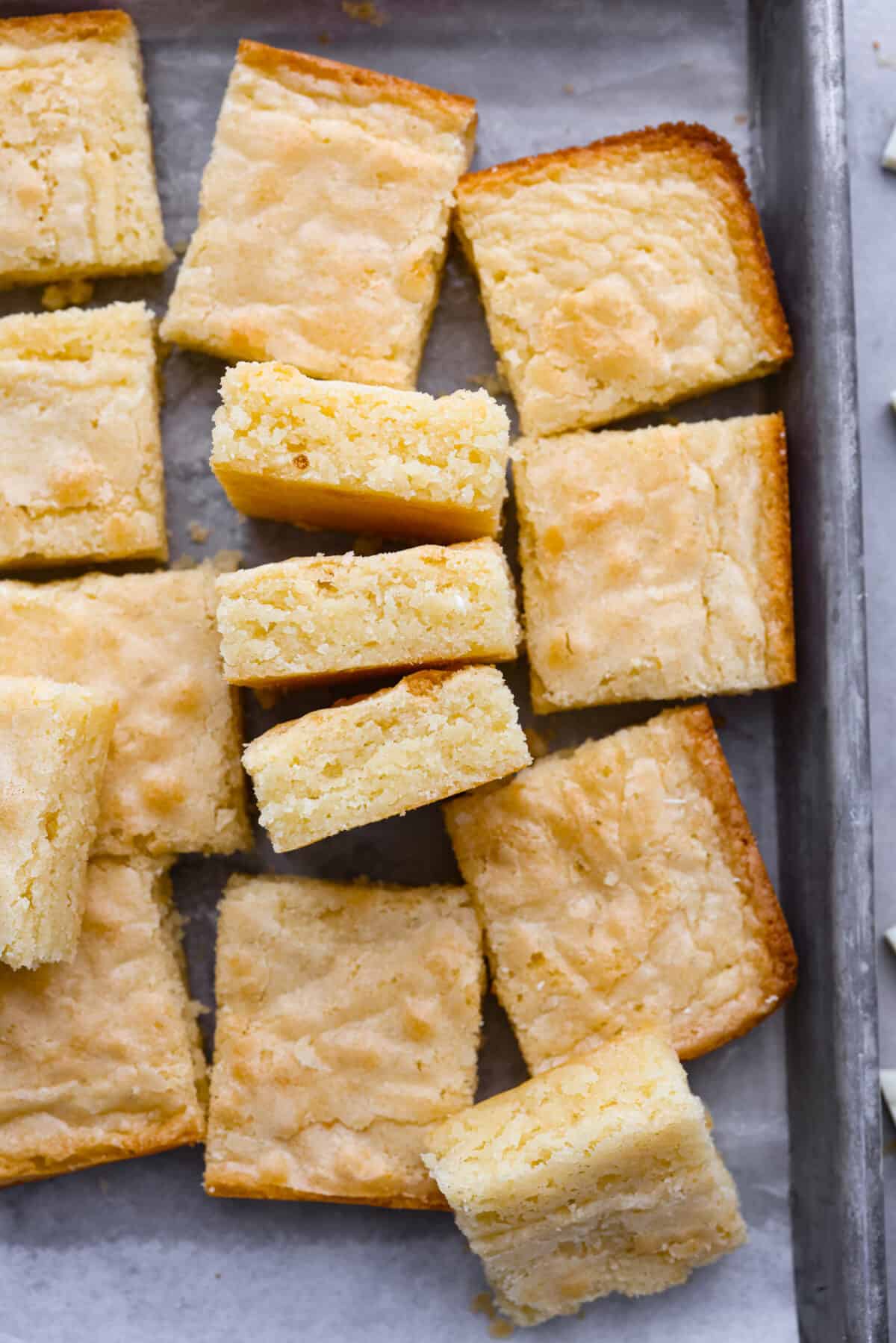 Moist, chewy, and loaded with creamy white chocolate flavor, these brownies will be your new favorite dessert. It only takes a few pantry staples to whip them up and they turn out perfectly every time. Top-down view of white chocolate brownies in a metal pan, cut into squares.