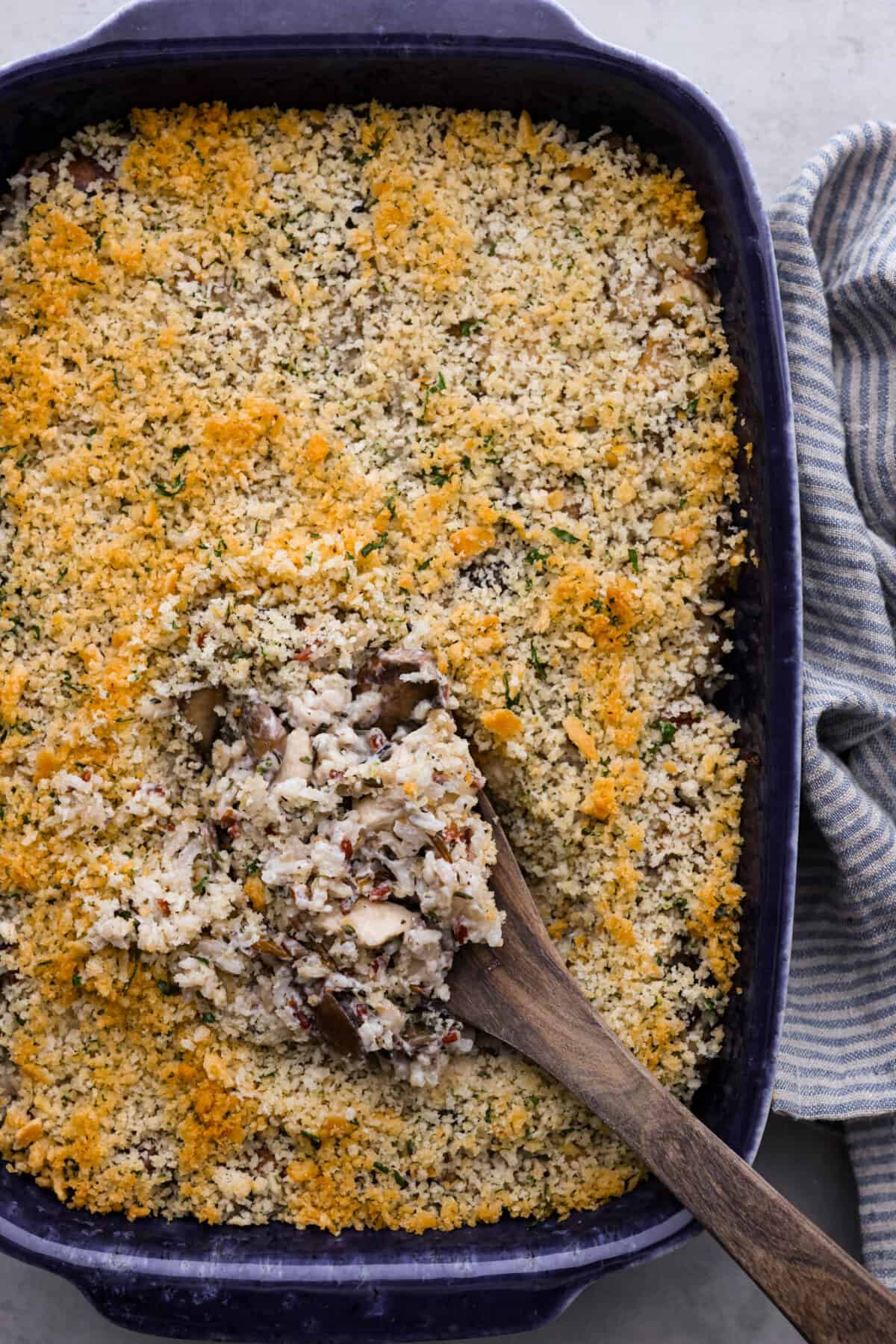 Chicken and wild rice casserole is an easy, comforting meal that the whole family will enjoy! You just can't go wrong with tender chicken and wild rice in a creamy sauce, and topped off with buttery breadcrumbs. Top-down view of chicken and wild rice casserole in a black baking dish.