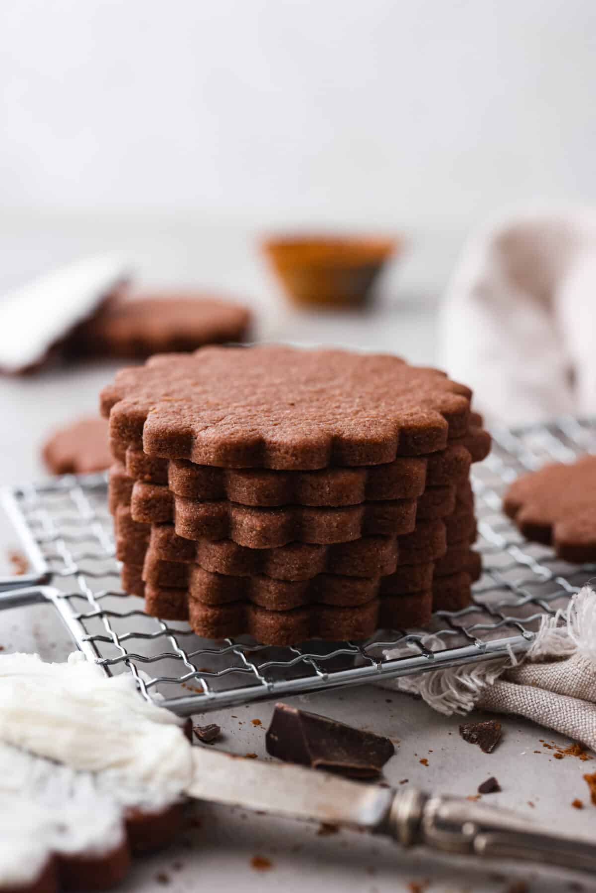 Chocolate sugar cookies are buttery, tender and melt in your mouth with each delicious bite! These are the perfect elevated cookies to cut out and frost for Valentine's Day, or any day! 6 chocolate sugar cookies stacked on top of each other.