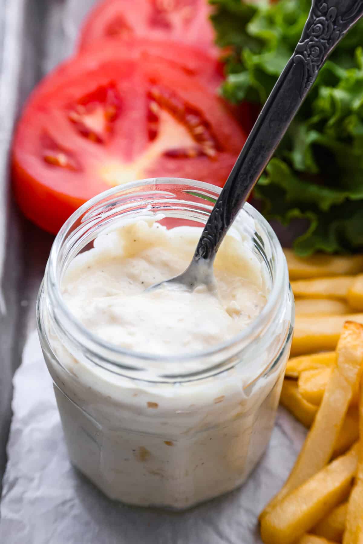 Slather this creamy donkey sauce on your next burger, or serve it with a side of fries! The roasted garlic in this flavor-packed condiment takes this sauce to the next level! Guy Fiery knew how to create a burger sauce the world can't live without! Close view of donkey sauce in a glass jar with a spoon.