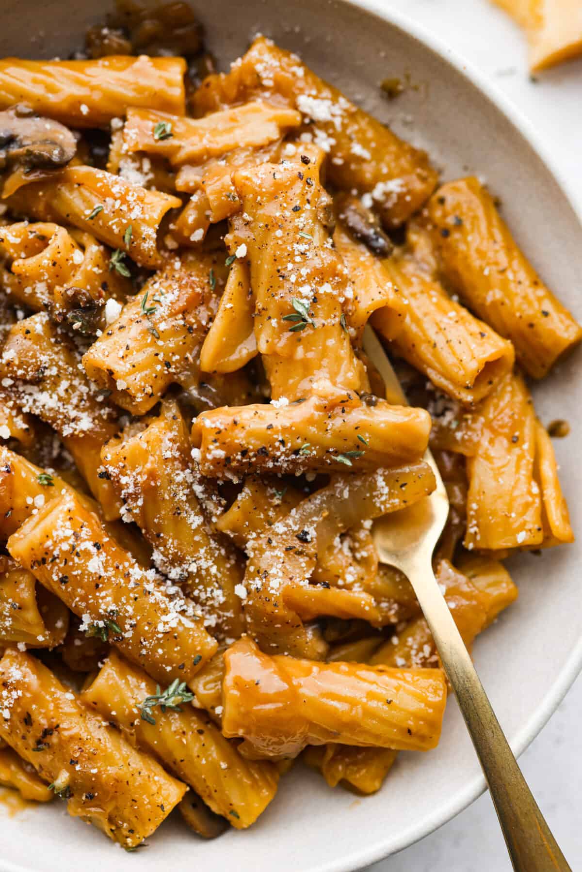 French Onion Pasta has all of the delicious flavors of the classic soup in pasta form! Caramelized onions, garlic, mushrooms, and thyme are combined with beef broth, pasta, Worcestershire sauce and parmesan cheese to create an incredible dish. Closeup of the French onion pasta.