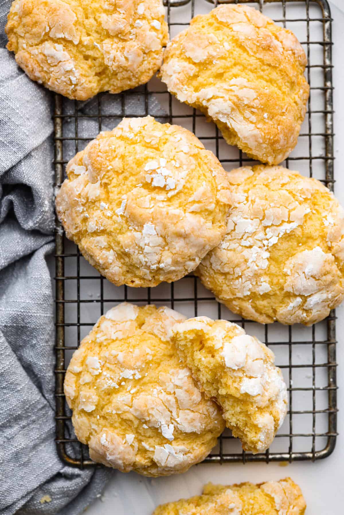 Rich, chewy, and topped with a dusting of powdered sugar, these gooey butter cookies are every cookie lover’s dream! You only need a handful of simple ingredients to make them. Give them a try and watch them fly off the table! Top-down view of butter cookies on a wire rack.