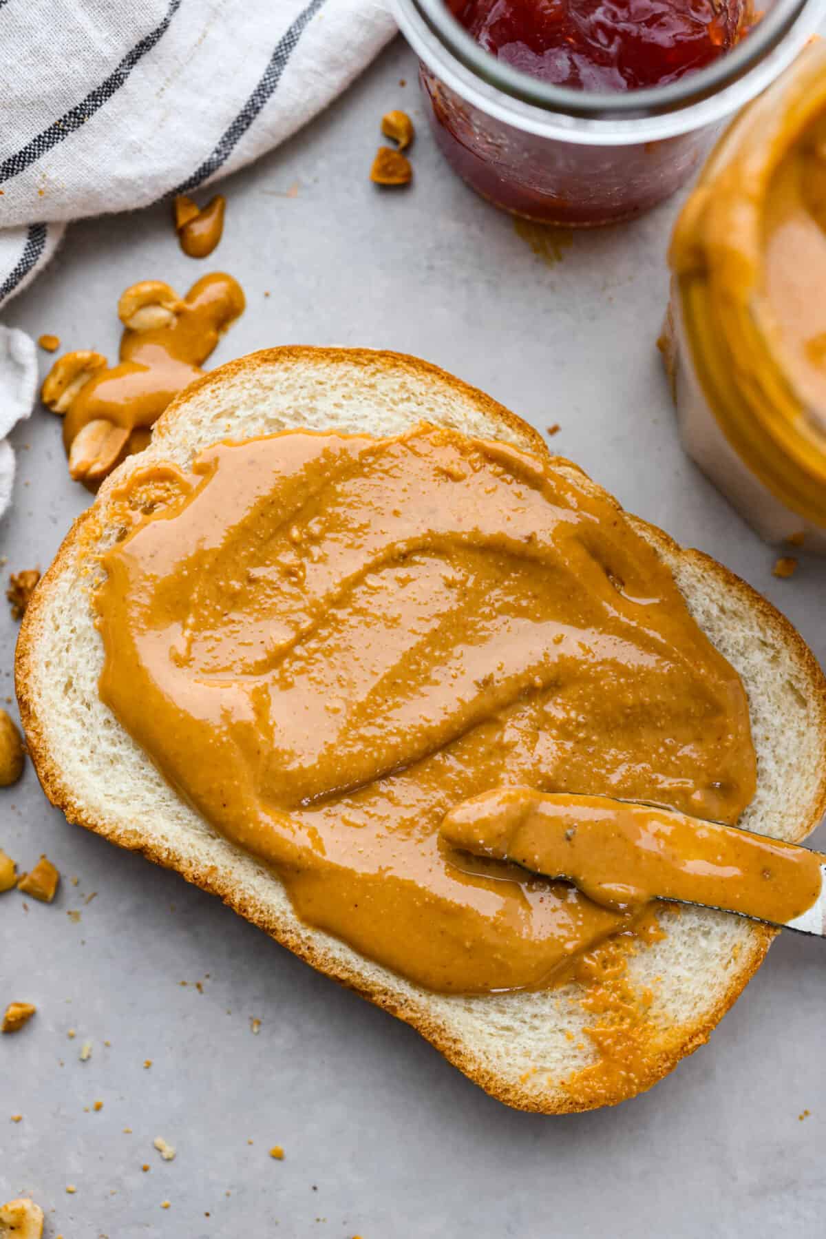 Skip the preservatives and make your own homemade peanut butter in minutes with this easy recipe! So simple and delicious, you won't want it any other way. Peanut butter spread over a piece of bread.
