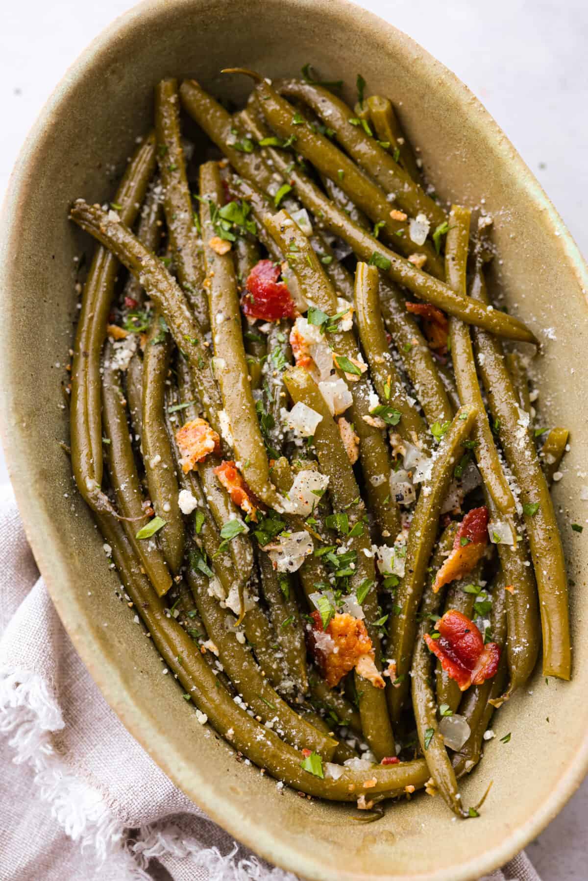These Crockpot Green Beans are perfectly tender, packed with flavor and so easy to cook in your slow cooker. All you need is 5 minutes of prep time to have a side dish that pairs well with almost any meal! Crockpot green beans in a serving dish.