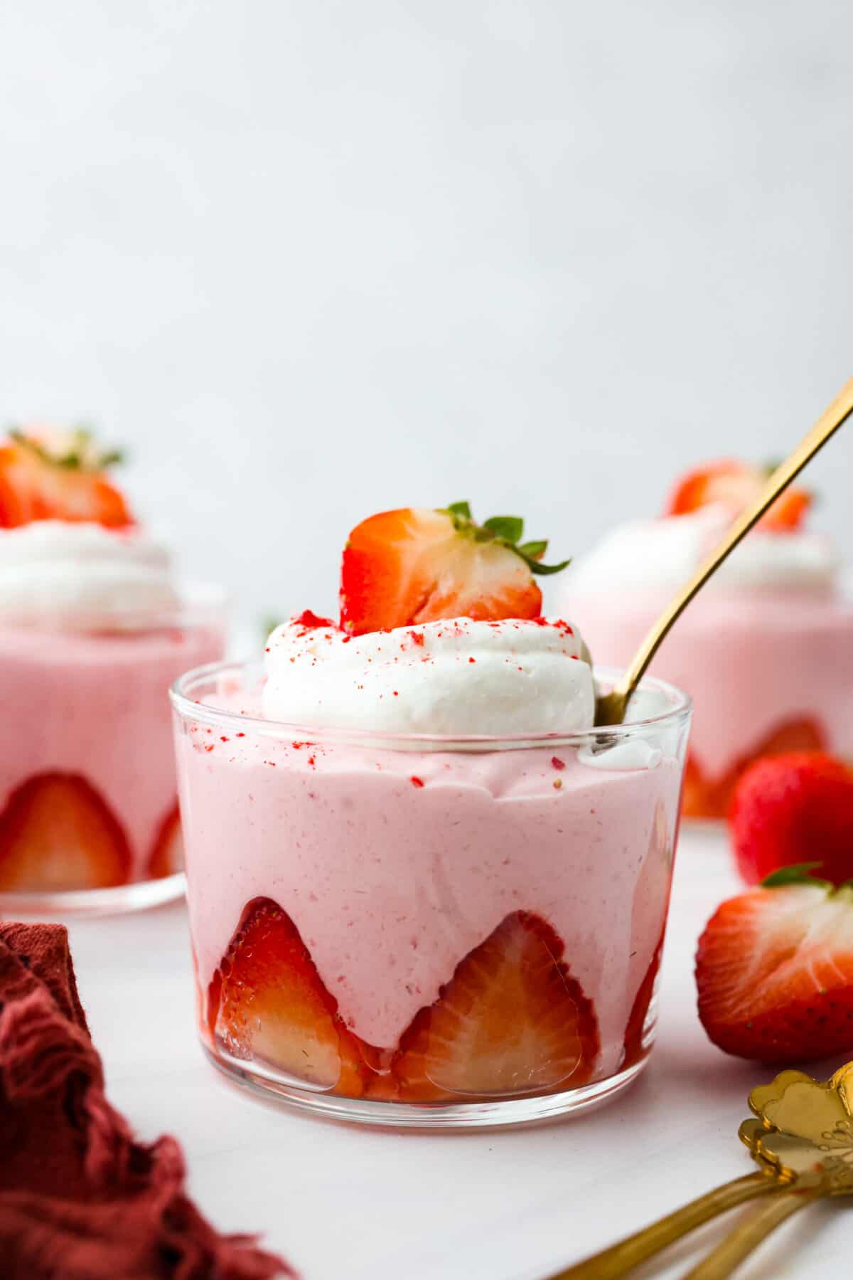 Deliciously sweet and creamy, this Strawberry Mousse is a dessert that looks impressive, yet is so easy to make. It tastes amazing, is bursting with fruity flavor, and would be the perfect treat for any occasion! Strawberry mousse in a glass cup lined with sliced strawberries.