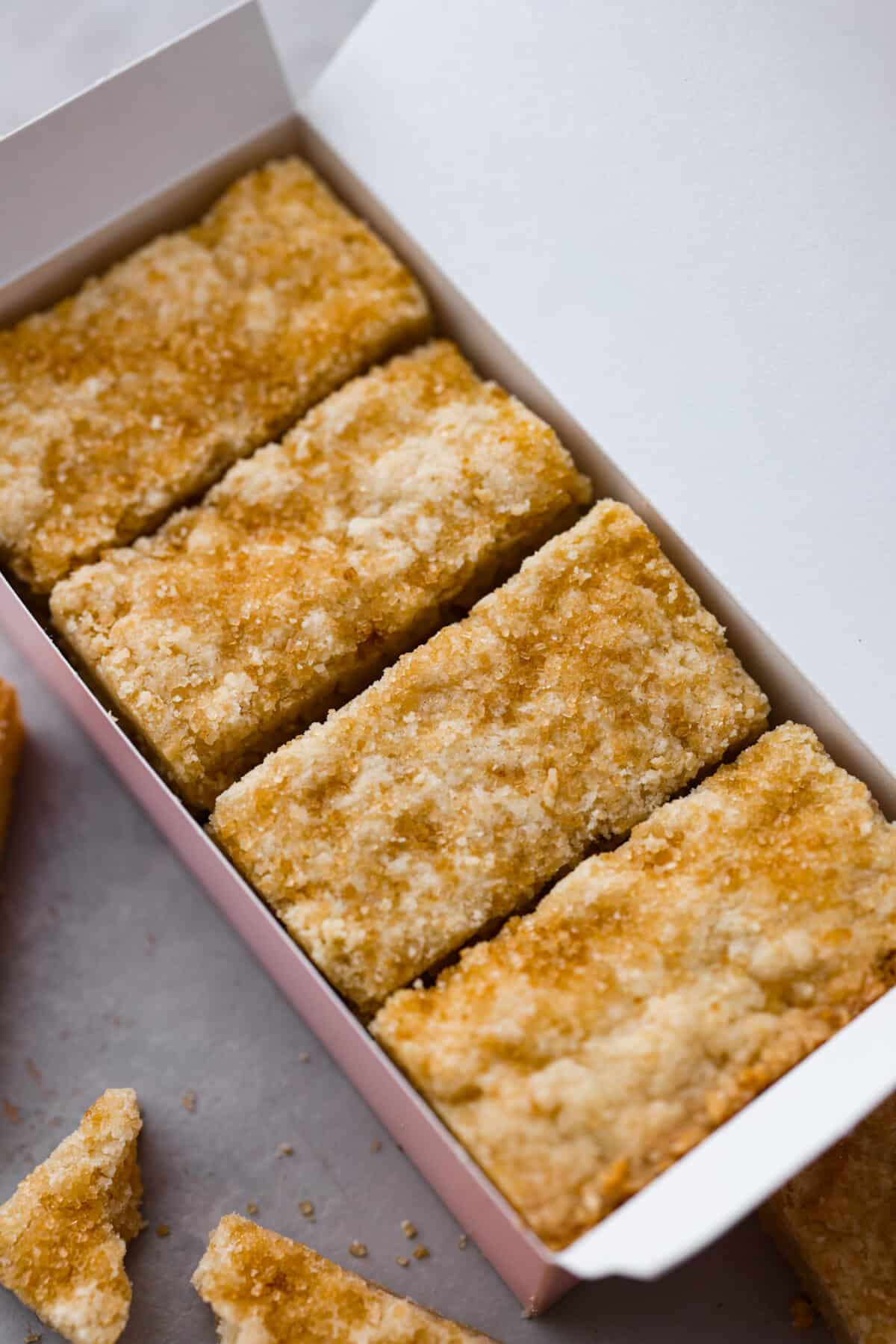 After tasting these delicious Ted Lasso Biscuits in real life, you'll understand just why Rebecca was obsessed with them! They are sweet and have the perfect shortbread texture. A closeup of Ted Lasso biscuits in a pink box.