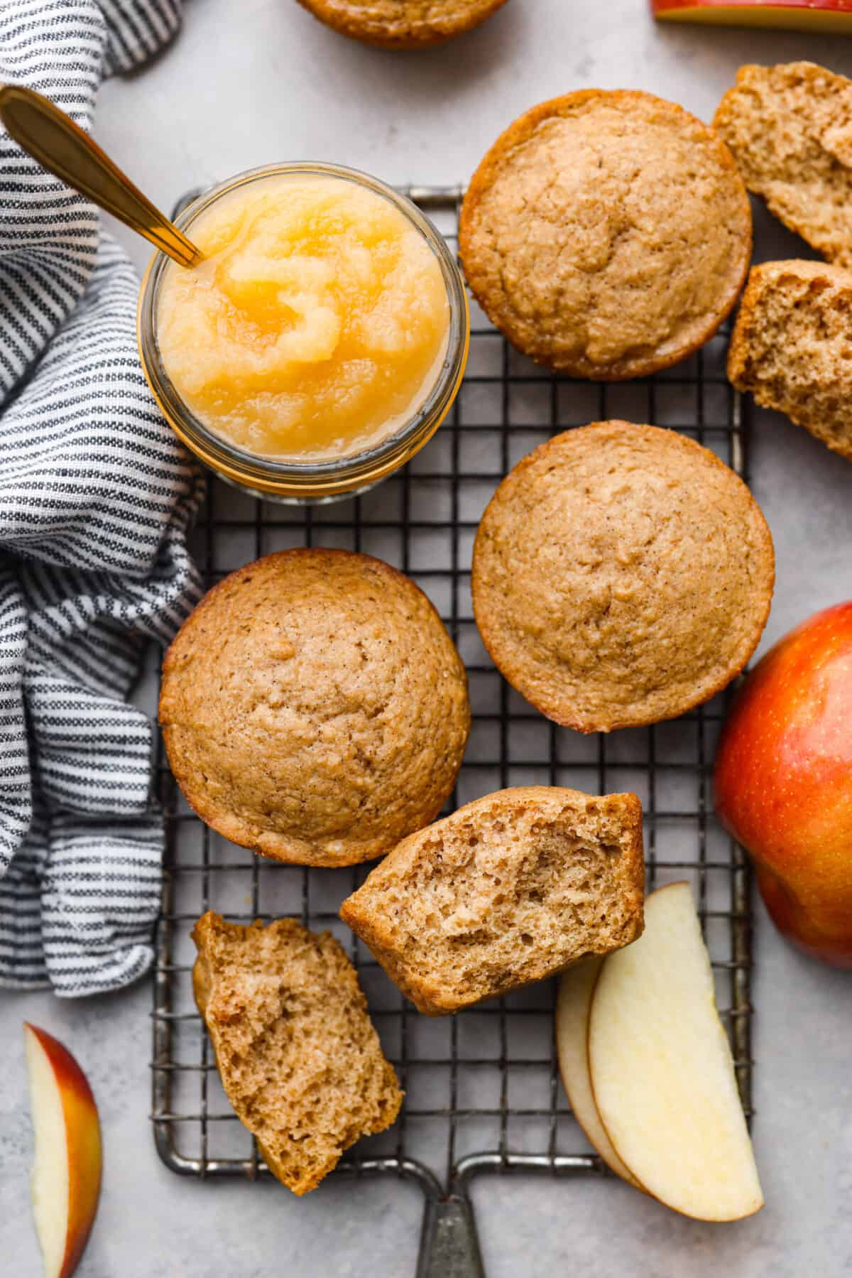 I see a batch of sweet and ultra-moist applesauce muffins in your future! Theyโre so delicious and made with all-natural sugars. The perfect breakfast, snack, dessert, you name it! Top-down view of applesauce muffins on a wire rack. One is torn in half.